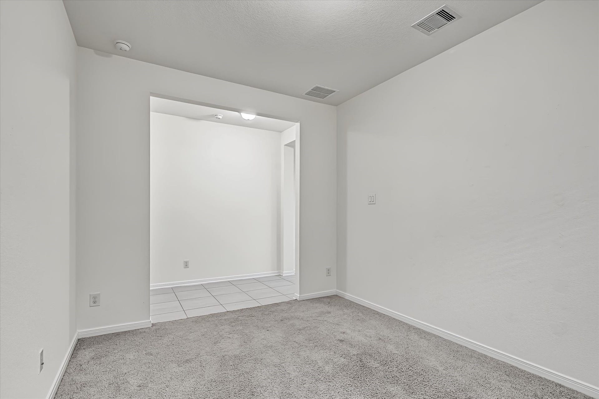 9607 Bright Song Lane, Houston, TX 77078 Cozy Game Room with soft carpeting, neutral walls, and a window allowing natural light to fill the space lading to hallway.