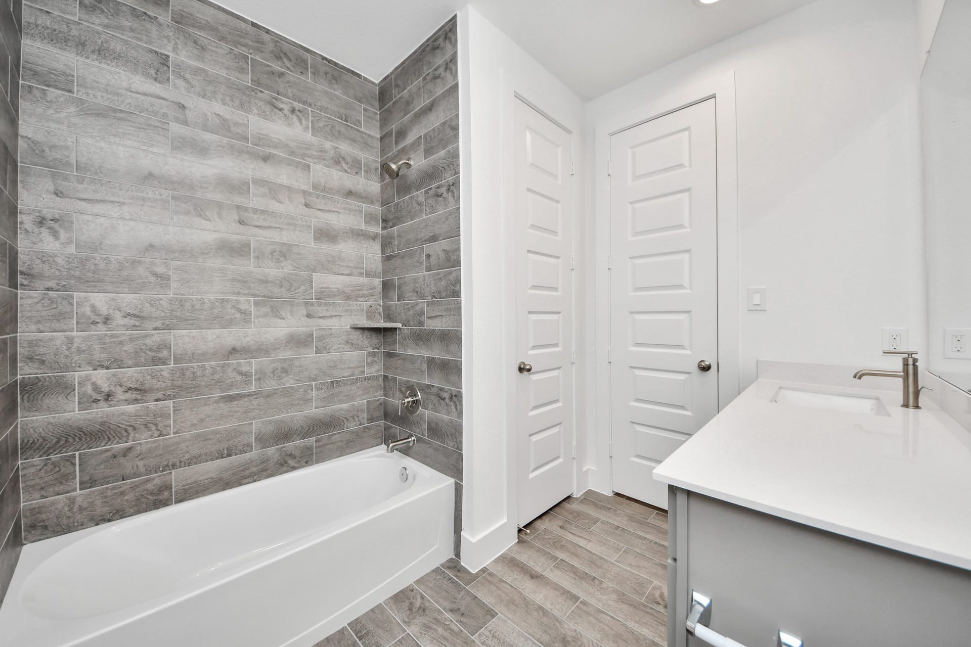 3201 Skerne Spring Drive, Spring, TX 77373 Secondary bath features tile flooring, bath/shower combo with tile surround, light stained wood cabinets, beautiful light countertop. Sample photo of completed home with similar floor plan. Actual colors and selections may vary.