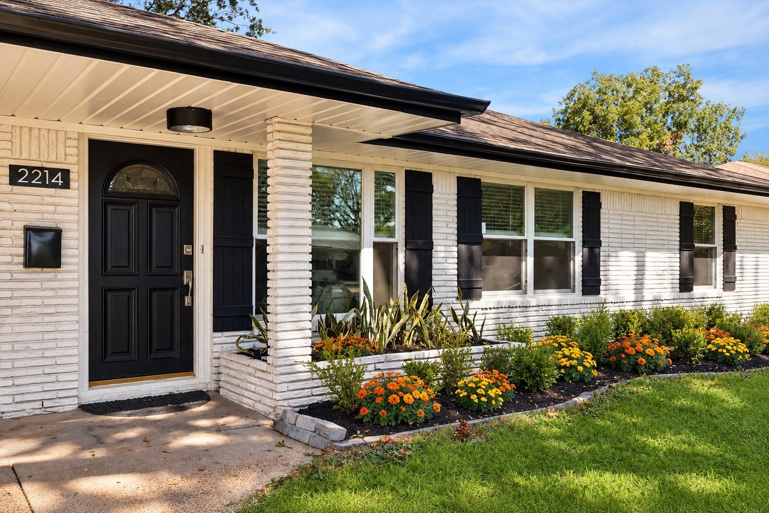 2214 Bron Holly Drive, Houston, TX 77018 White painted brick, contrasting black accents. This photo has been virtually staged for the flowers bed.