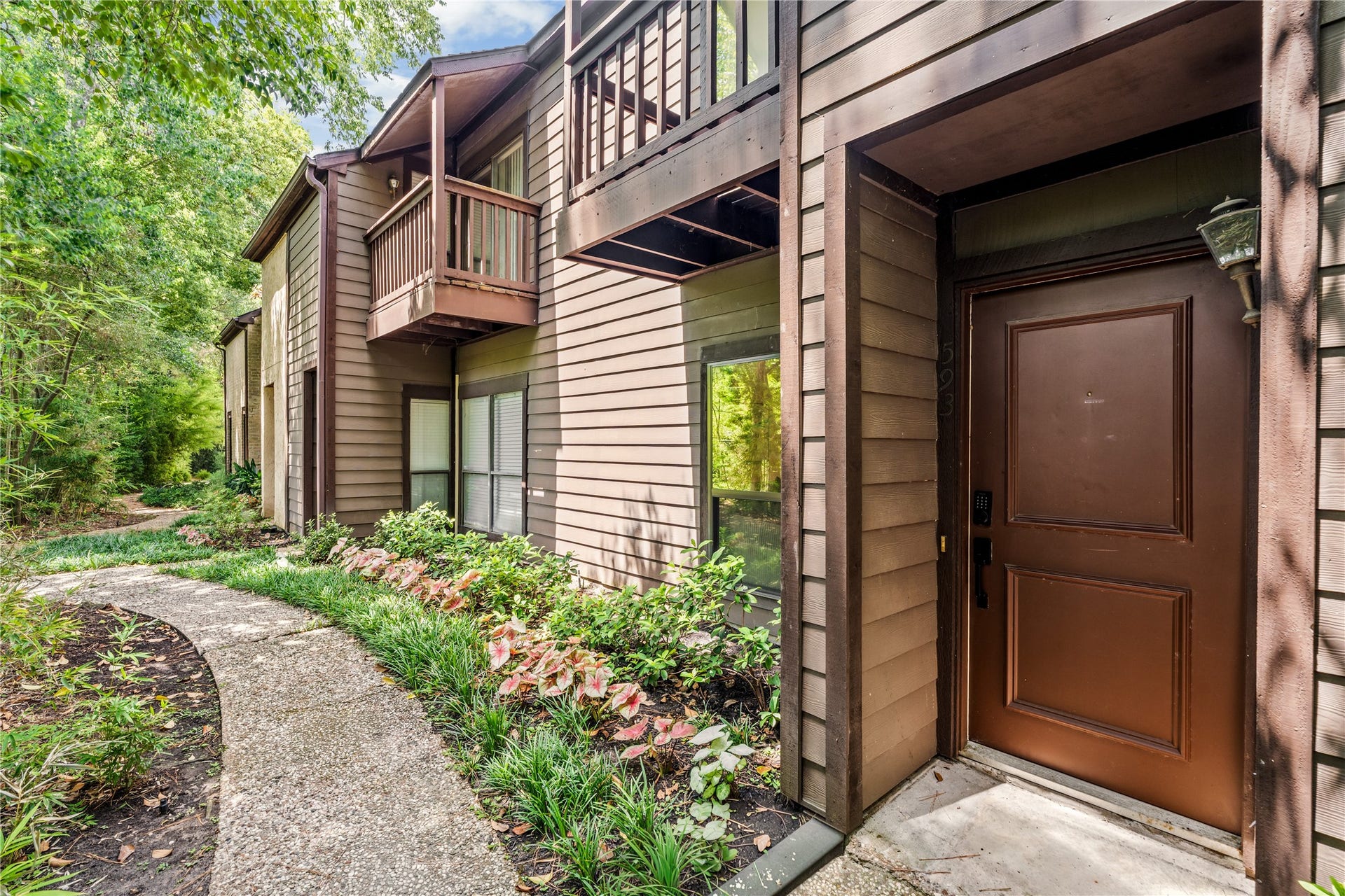 11711 Memorial Drive, #593, Houston, TX 77024 Tucked beneath a canopy of mature trees, the private entrance offers a quiet welcome home within the established Hudson Oaks community.