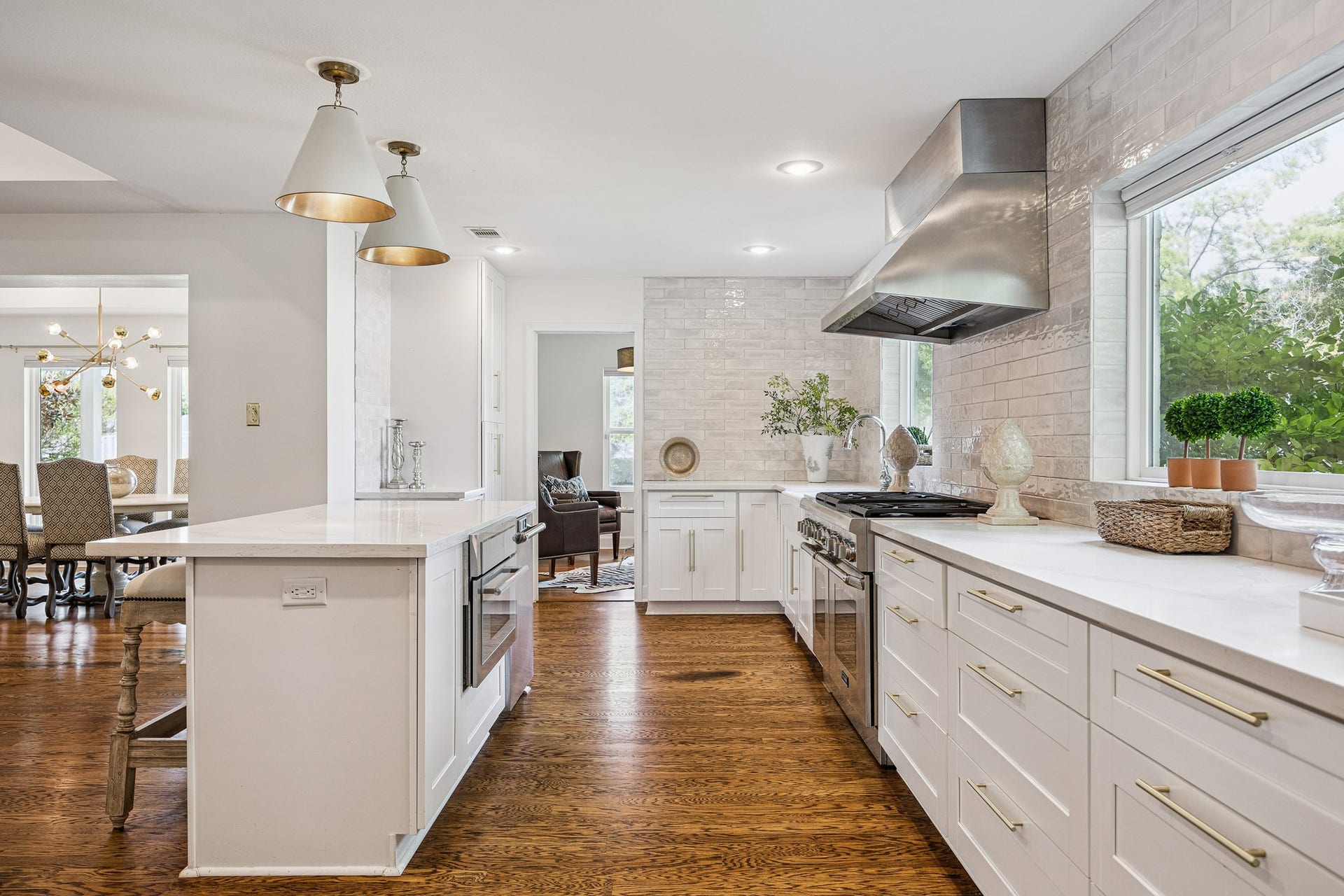 2503 Stoney Brook Drive, Houston, TX 77063 (25x10) This kitchen features a spacious island finished in quartz countertops, offering ample room for meal preparation and entertaining alike. The
stainless range and vent hood anchor the space
with a polished, well-appointed finish.