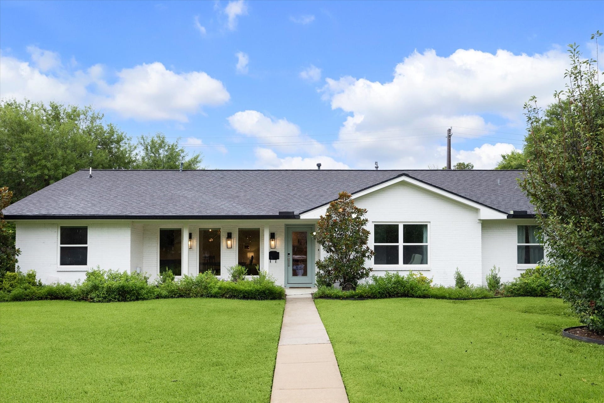 2503 Stoney Brook Drive, Houston, TX 77063 This beautiful white brick residence makes a
striking first impression, framed by a manicured
lawn and mature landscaping. A charming painted front door adds a pop of color against the crisp
faade, setting the tone on this corner lot.
