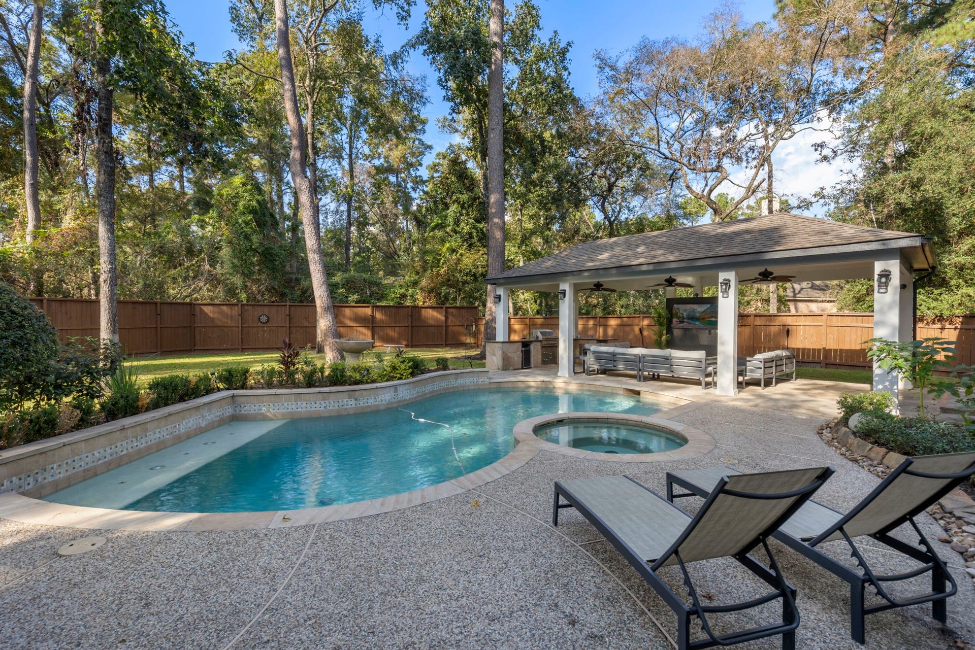 90 W Horizon Ridge Place, Spring, TX 77381 This dreamy outdoor space features a rare oversized lot with an extended covered patio, summer kitchen, and a pool/spa, all with no rear neighbors for added privacy!