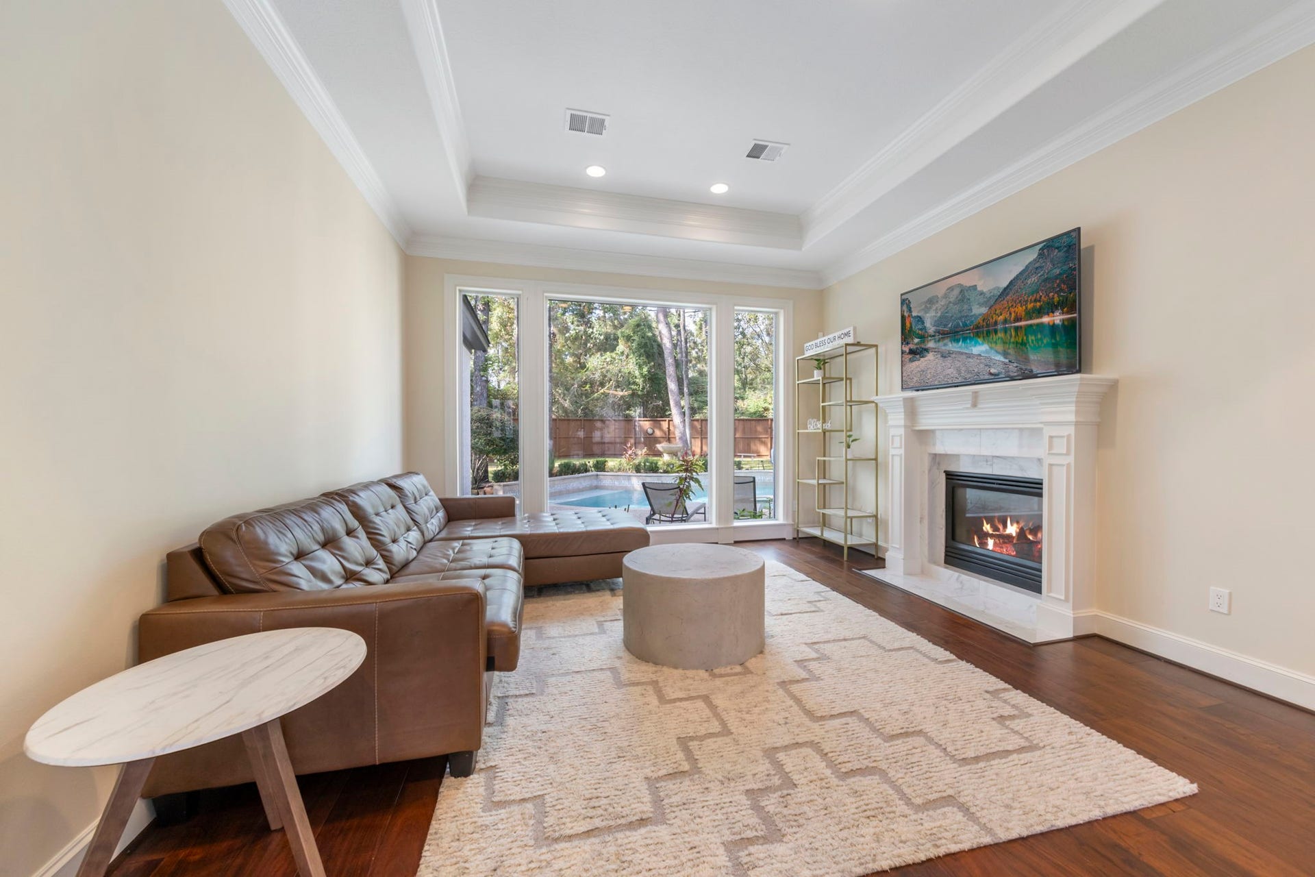 90 W Horizon Ridge Place, Spring, TX 77381 Den situated off formal dining features tray ceiling, cozy fireplace and wall of windows offering ample natural light.