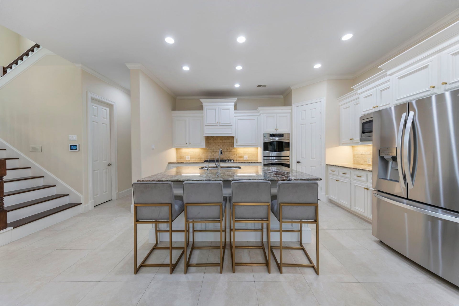 90 W Horizon Ridge Place, Spring, TX 77381 Spacious kitchen offers granite counter tops, oversized island with additional seating, two walk-in pantries, and generous amount of storage space. Back staircase offers easy access to the kitchen.