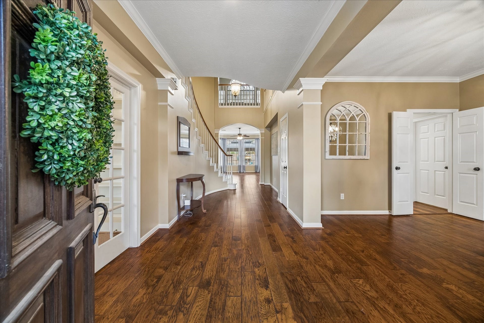 5310 Summerland Ridge Court, Houston, TX 77041 This welcoming entryway features elegant hardwood floors, neutral walls, and a curved staircase leading to the upper level. Decorative arches add charm, while ample natural light brightens the space.