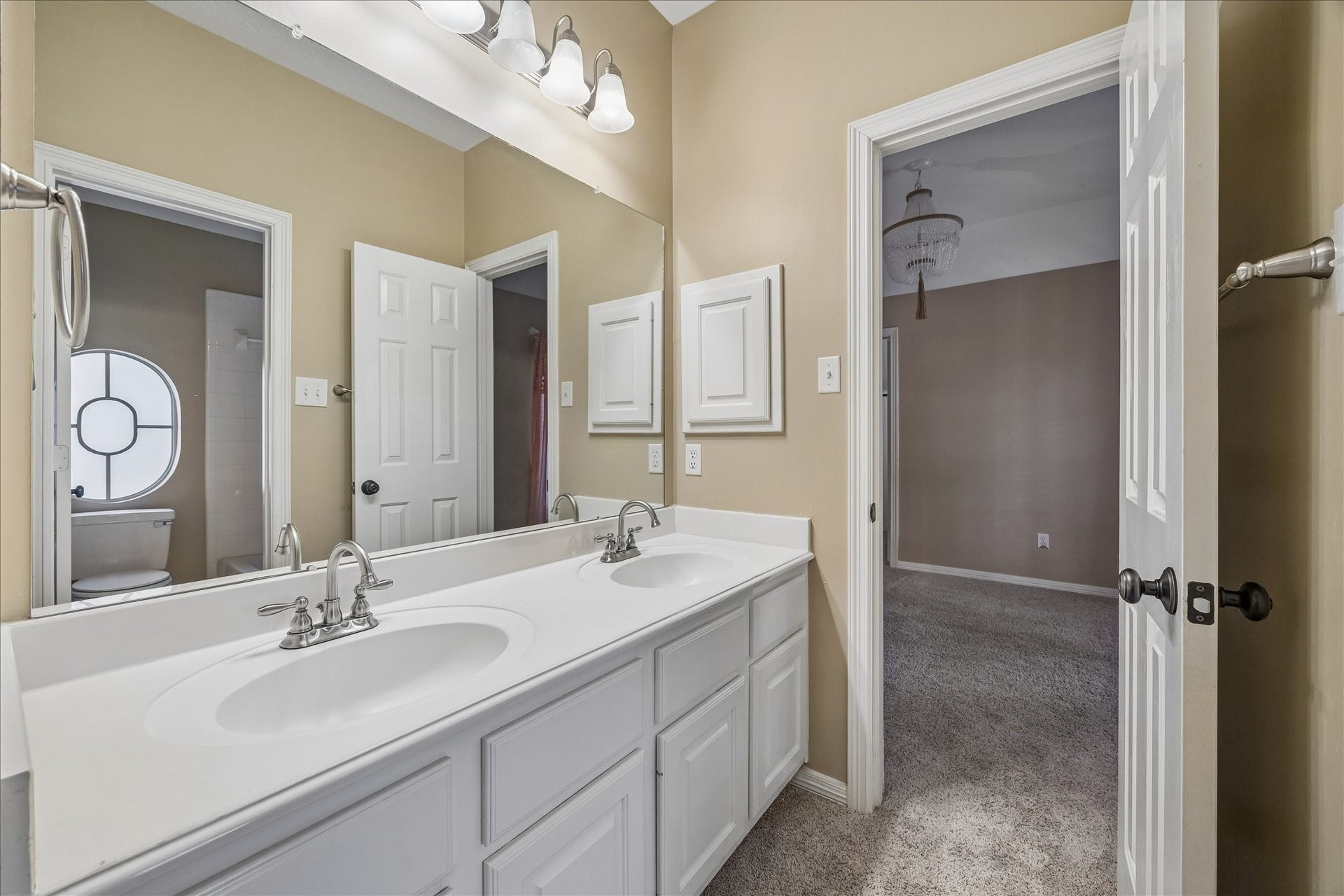 5310 Summerland Ridge Court, Houston, TX 77041 This jack and jill bathroom shows a dual-sink bathroom with white cabinetry and modern fixtures. It connects to a secondary bedroom.