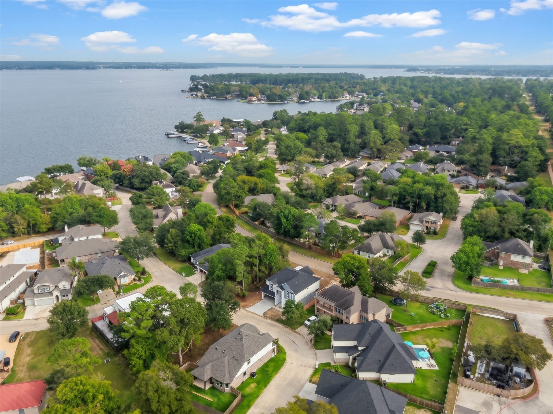 12195 N Lake Vista Drive, Willis, TX 77318 Nestled in a lush, green neighborhood, this serene lakeside community offers stunning water views and beautifully maintained homes, perfect for tranquil living.