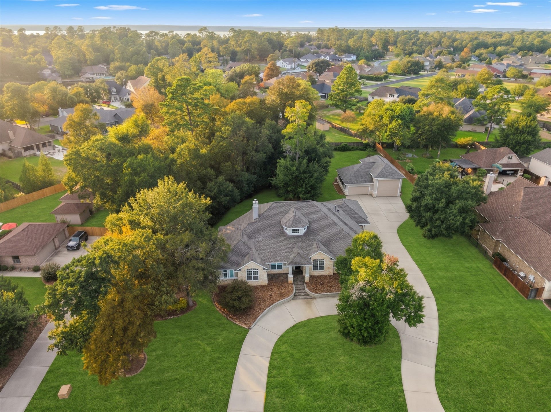 12195 N Lake Vista Drive, Willis, TX 77318 Nestled in a lush, tree-lined neighborhood, this elegant home boasts a spacious, winding driveway and expansive green lawns, offering a serene retreat with a picturesque aerial view.