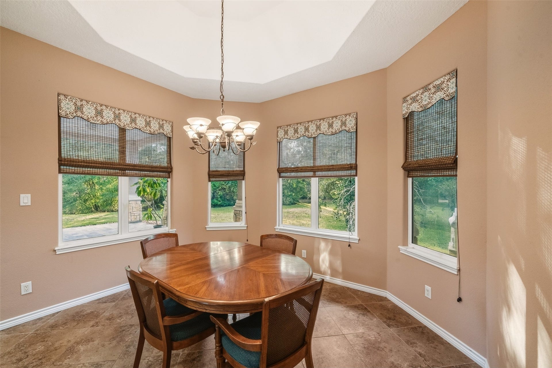 12195 N Lake Vista Drive, Willis, TX 77318 Sunlit breakfast room with charming windows and elegant tile flooring, perfect for morning gatherings.