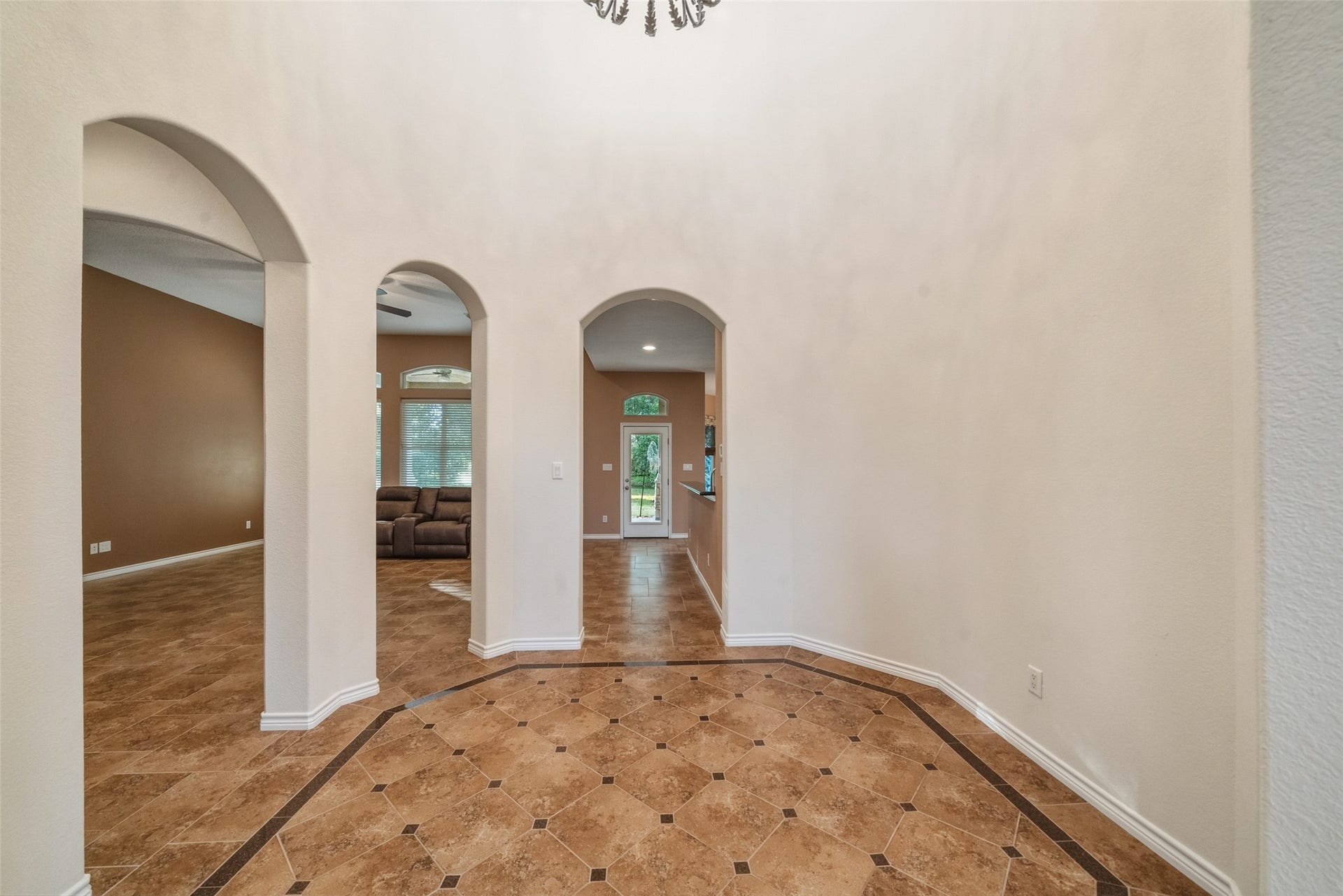 12195 N Lake Vista Drive, Willis, TX 77318 Bright breakfast nook with large windows offering serene garden views, featuring a charming chandelier above a cozy wooden dining set.