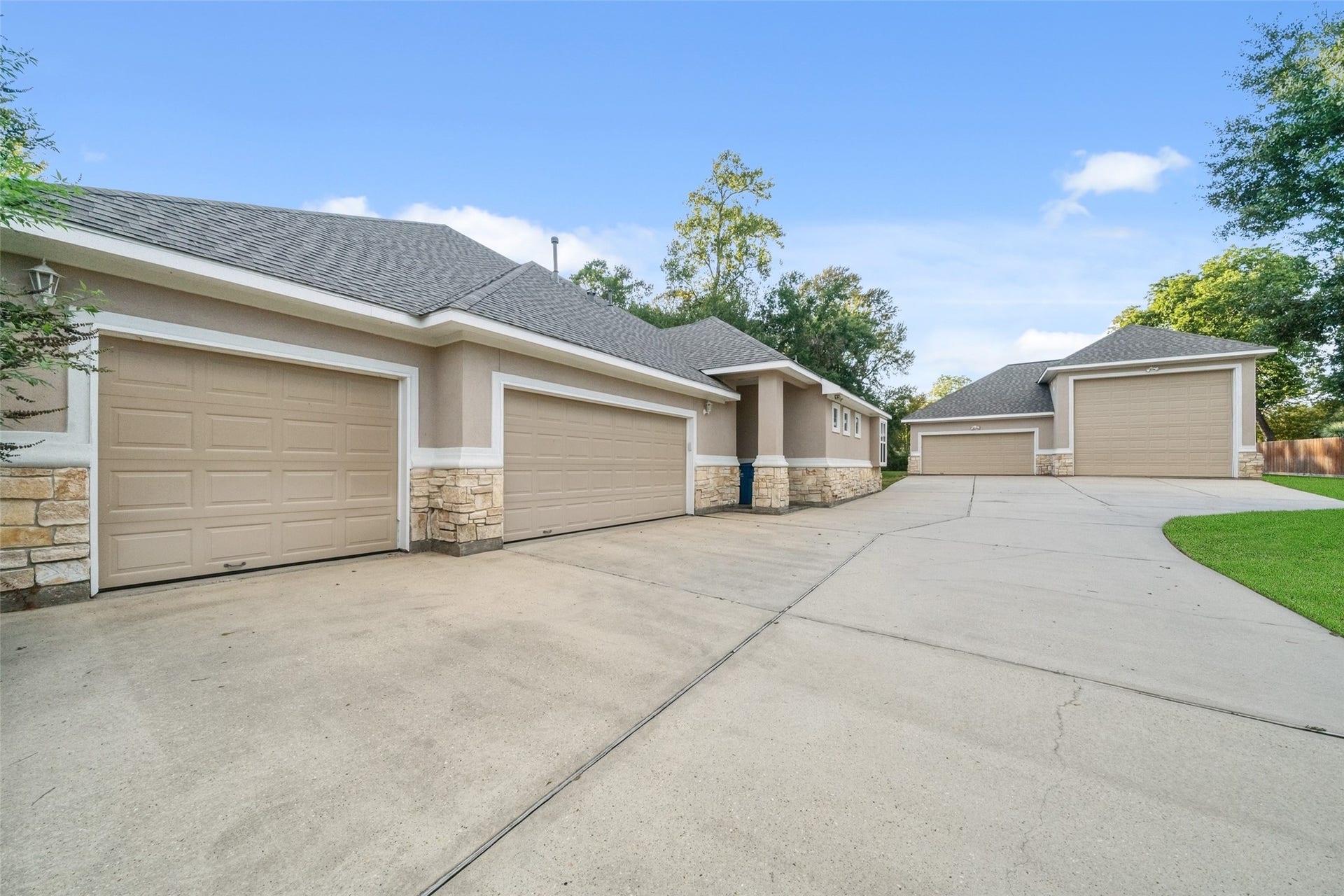 12195 N Lake Vista Drive, Willis, TX 77318 Expansive 3-car garage with a spacious driveway leading to an RV garage, perfect for all your vehicles and adventures.