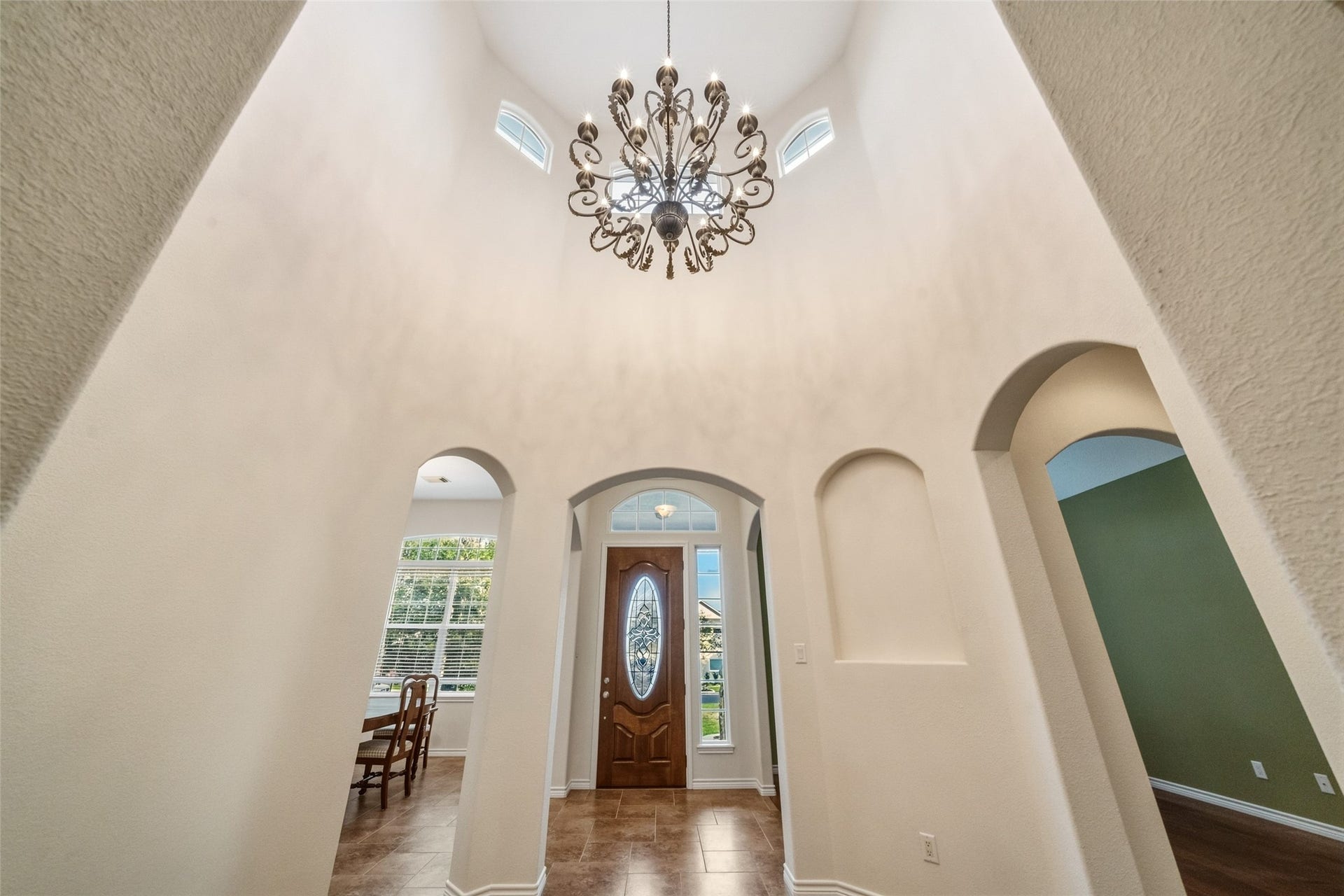12195 N Lake Vista Drive, Willis, TX 77318 Step into a bright and inviting foyer featuring elegant hardwood floors, a large window that bathes the space in natural light, and a stylish ceiling fan, seamlessly connecting to the rest of the home.