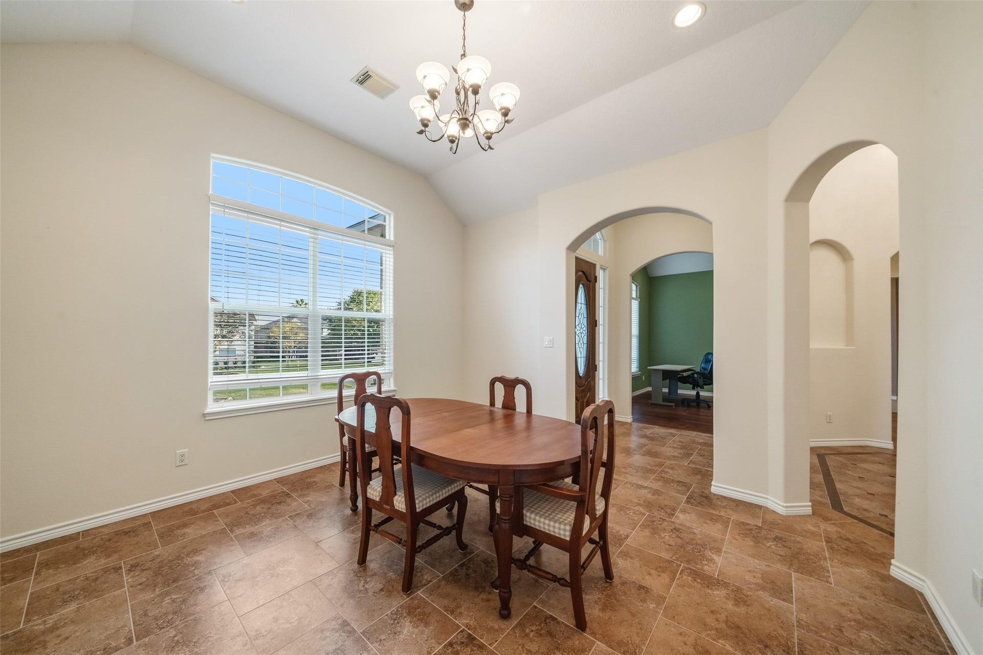 12195 N Lake Vista Drive, Willis, TX 77318 Experience elegant dining in this spacious, light-filled room featuring a vaulted ceiling, classic chandelier, and large window offering scenic views.