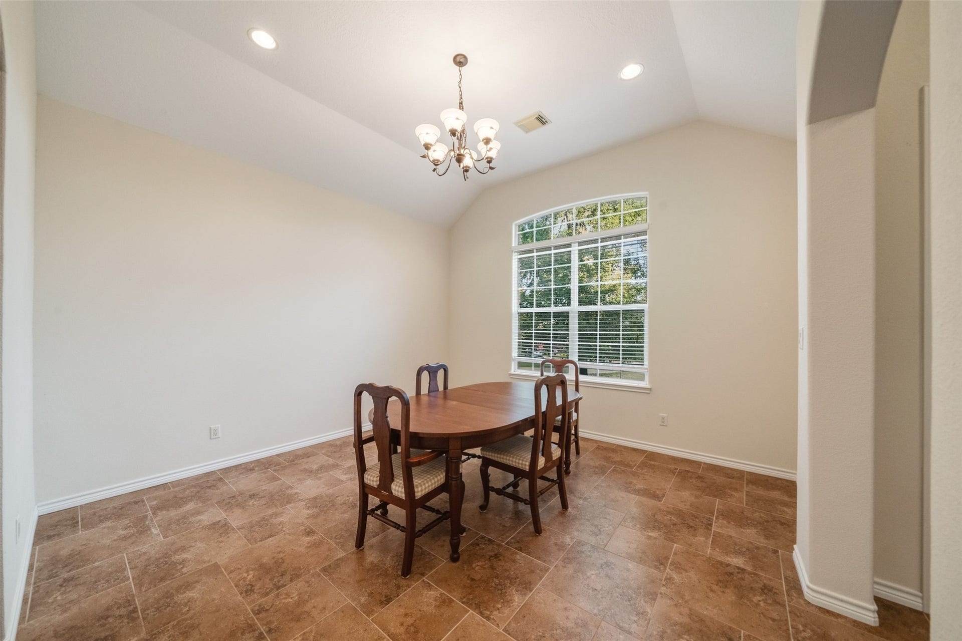 12195 N Lake Vista Drive, Willis, TX 77318 Step into elegance with this grand entryway featuring a stunning chandelier, leading to an inviting dining room perfect for hosting memorable gatherings.