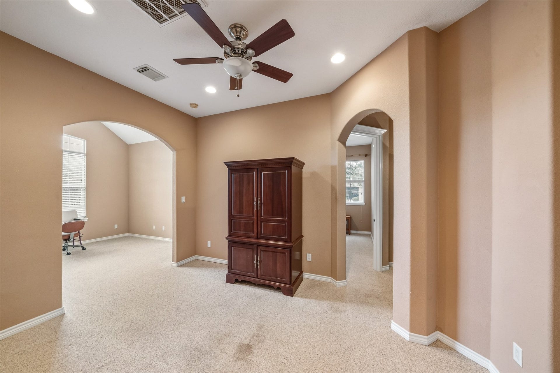 12195 N Lake Vista Drive, Willis, TX 77318 Spacious kitchen with elegant dark wood cabinetry, granite countertops, and dual islands, seamlessly flowing into a cozy living area featuring a stone fireplace.