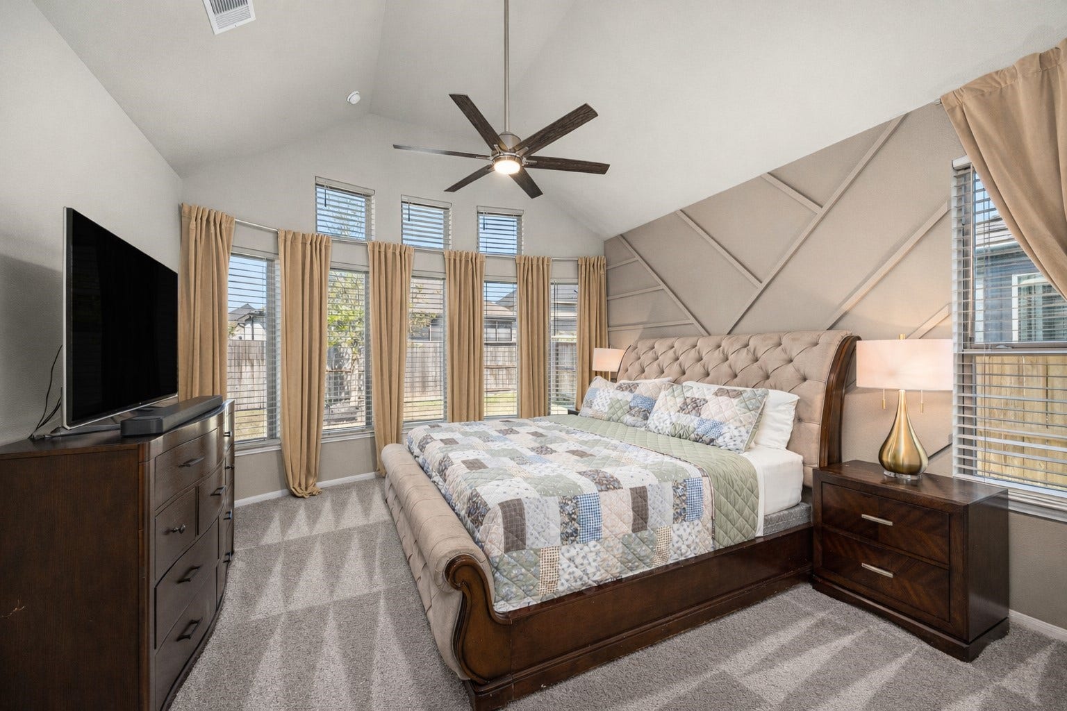 Primary bedroom with designer accent wall. High ceilings.