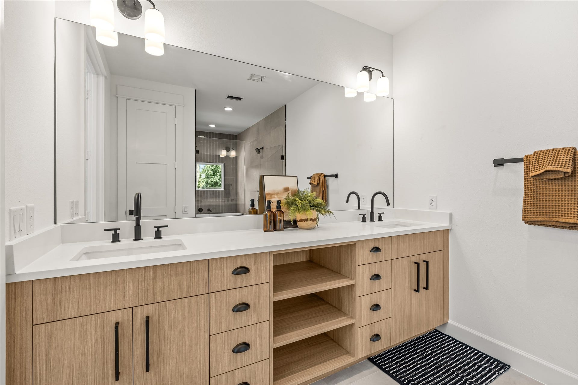 7432 & 7444 Tremper Street, Houston, TX 77020 Perspective view of the primary bathroom vanity highlighting the large frameless mirror and modern dual light fixtures.