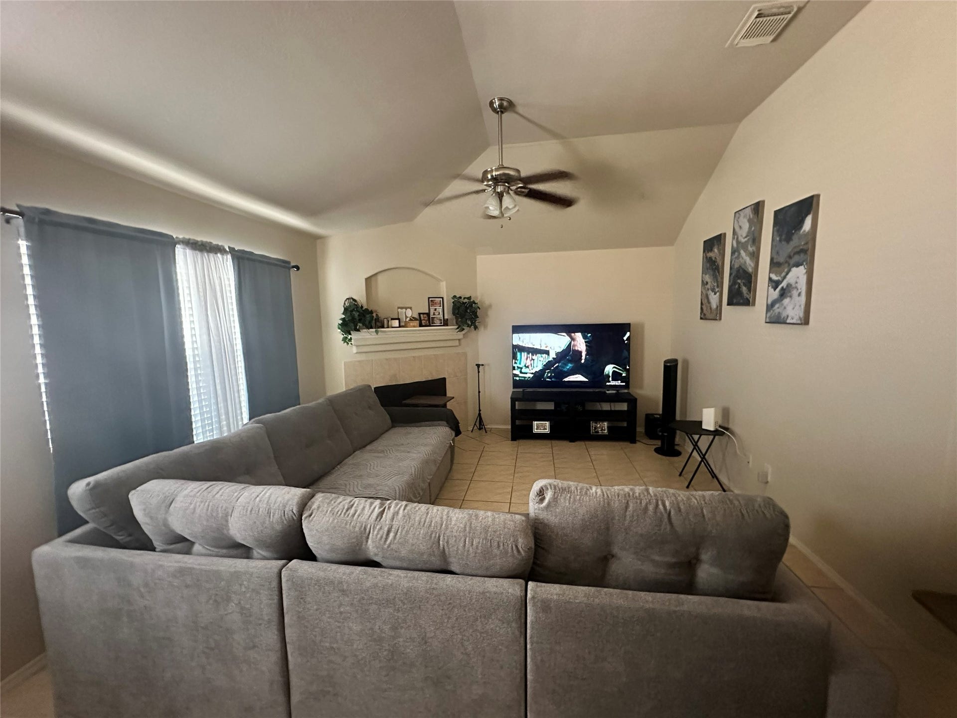 18234 Eton Ridge Court, Richmond, TX 77407 Spacious living room with vaulted ceilings, featuring a cozy gray sectional and a media setup, perfect for relaxation and entertainment.