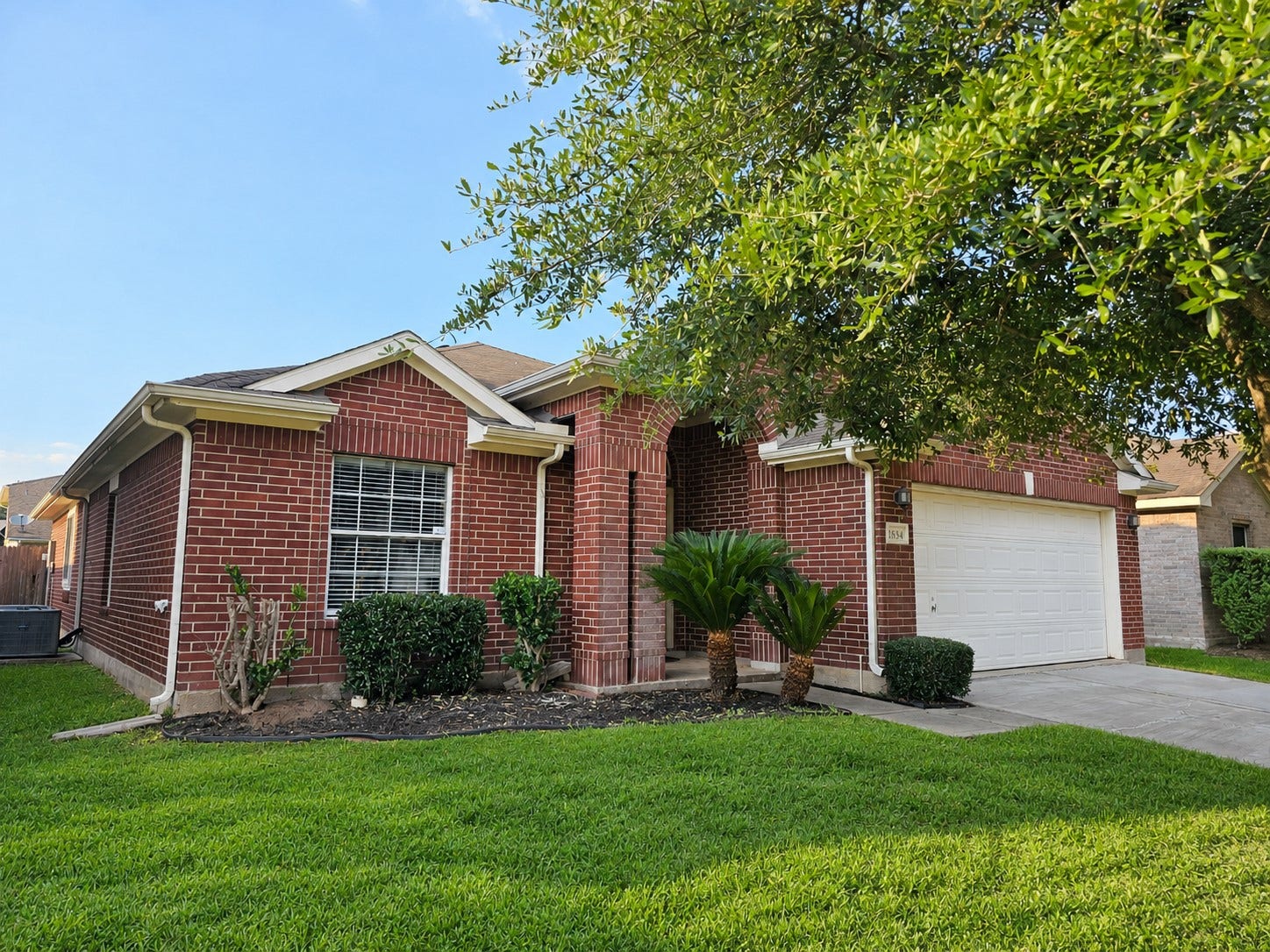18234 Eton Ridge Court, Richmond, TX 77407 Charming brick home with a welcoming front porch, well-maintained landscaping, and a spacious two-car garage.