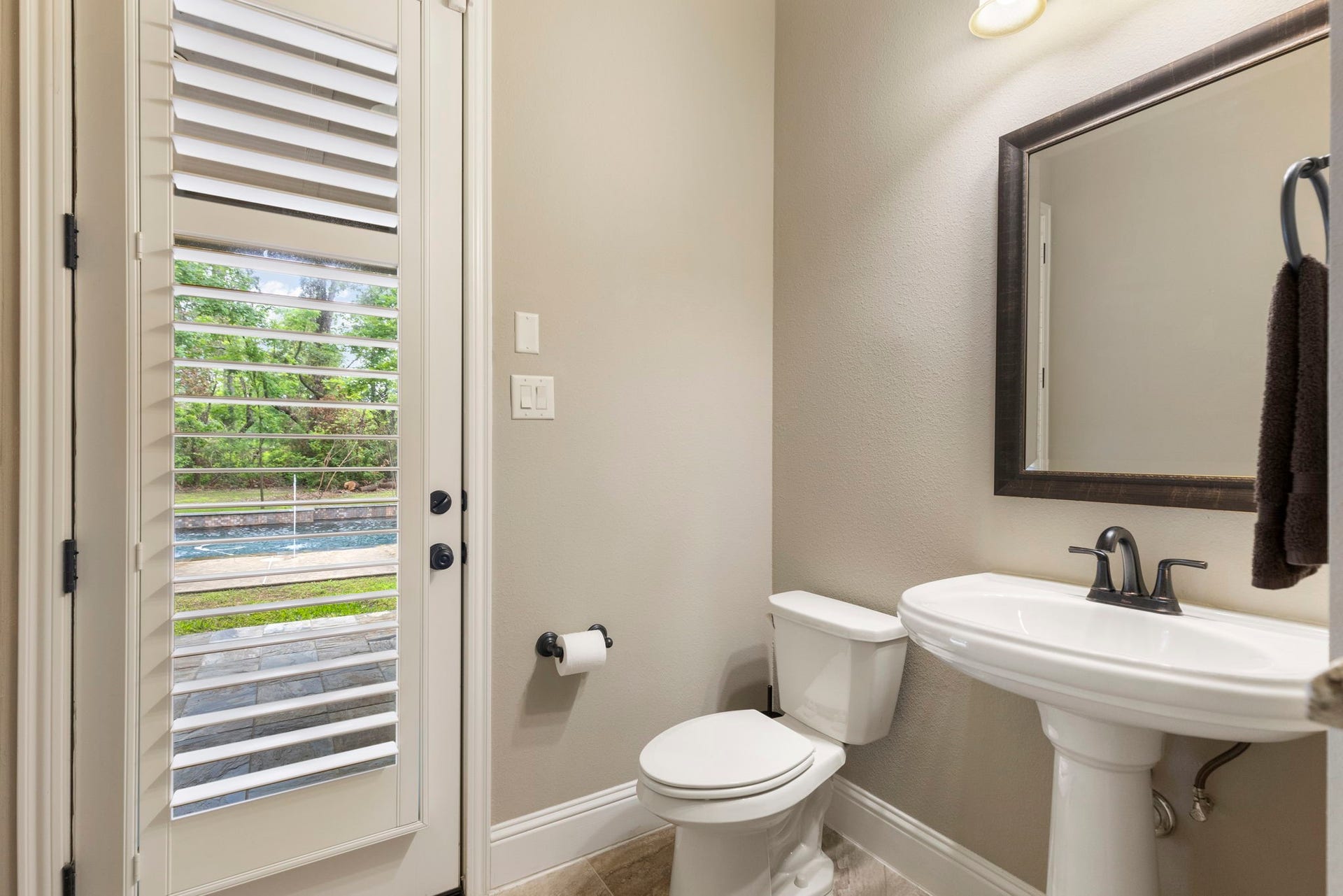 27015 Hidden Grove Landing Drive, Spring, TX 77386 Conveniently located off the Kitchen and Family Room, this Powder Bath features a pedestal sink, crown molding, built-in storage (perfect for pool towels), and direct access to the backyard and pool area.