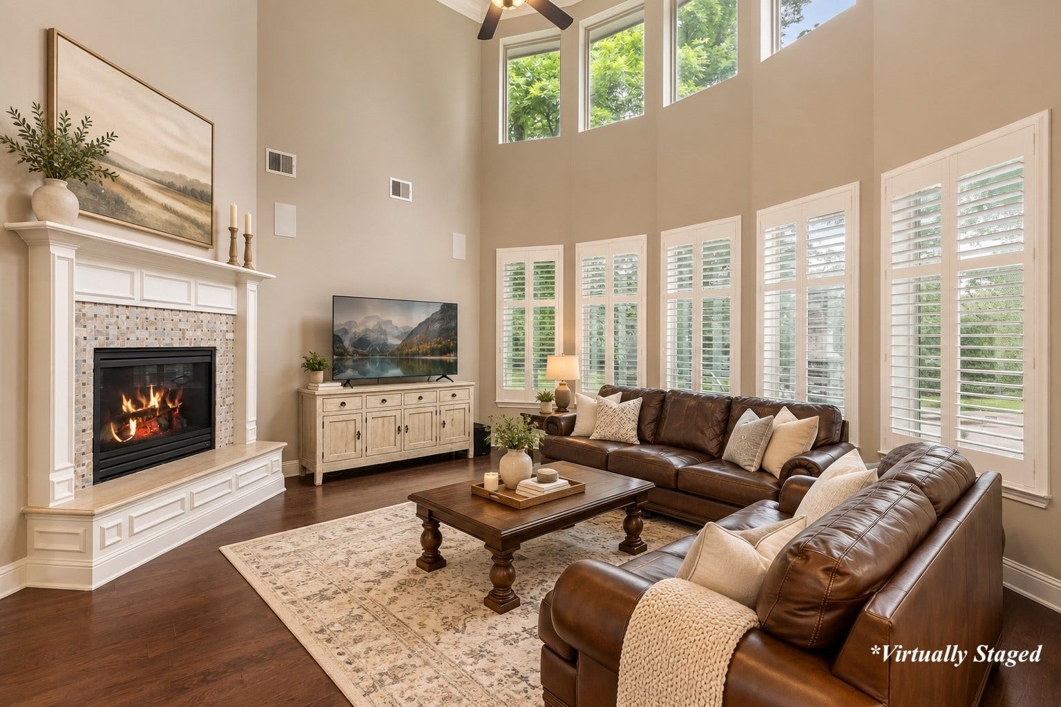 27015 Hidden Grove Landing Drive, Spring, TX 77386 Two-story Family Room with wood flooring, gas fireplace, surround sound, and expansive windows showcasing backyard views. *Virtually Staged decor accents