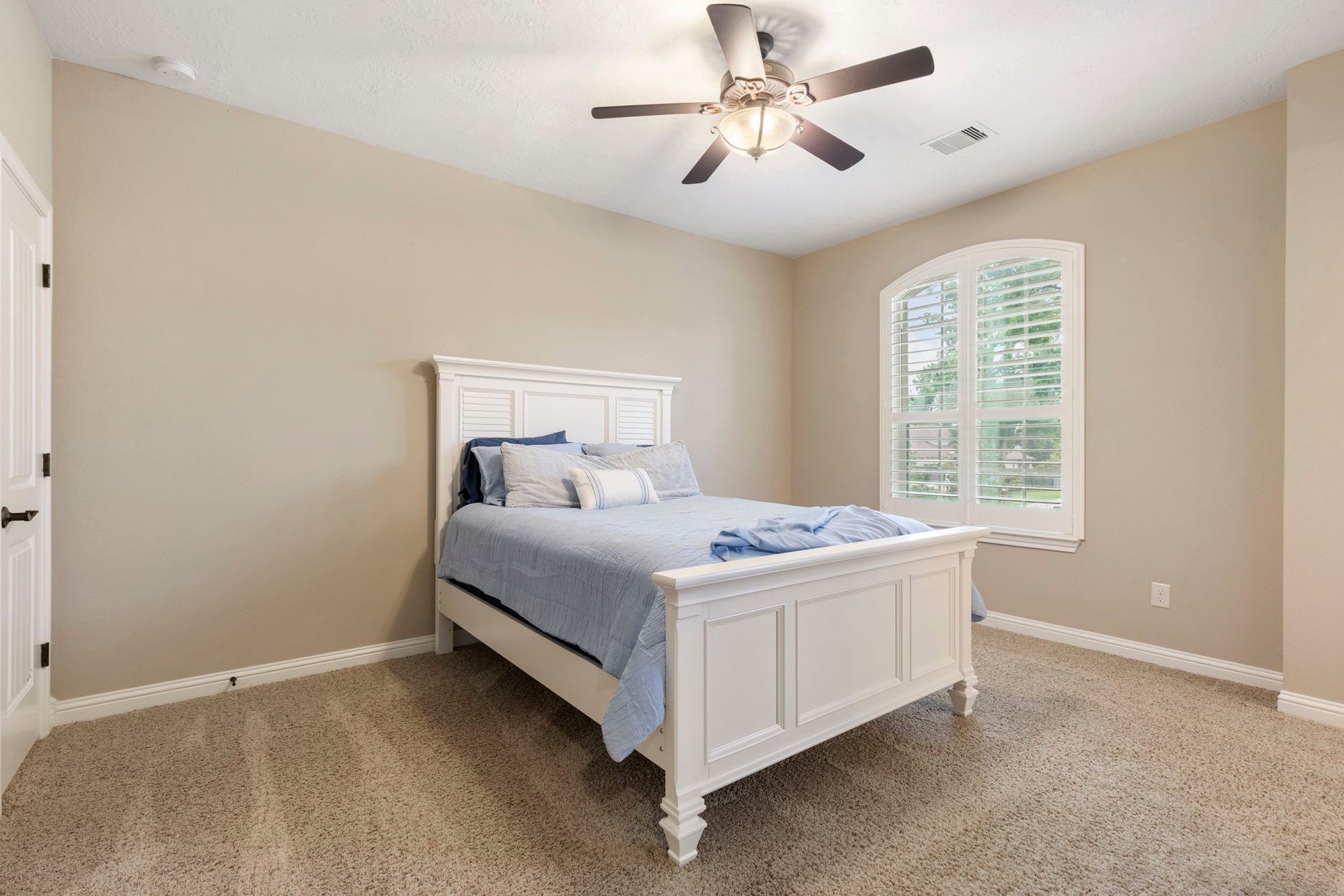 27015 Hidden Grove Landing Drive, Spring, TX 77386 Generously-sized upstairs Bedroom features carpeted flooring, ceiling fan, walk-in closet, and an arched window with plantation shutters.