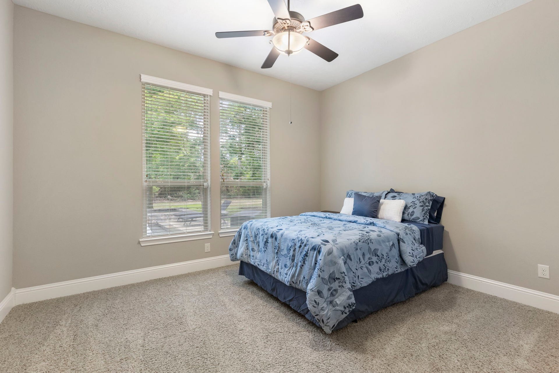 27015 Hidden Grove Landing Drive, Spring, TX 77386 Privately situated downstairs Guest Bedroom with backyard views, ceiling fan, double-door closet, and en-suite bathan ideal setup for visitors or extended stays.