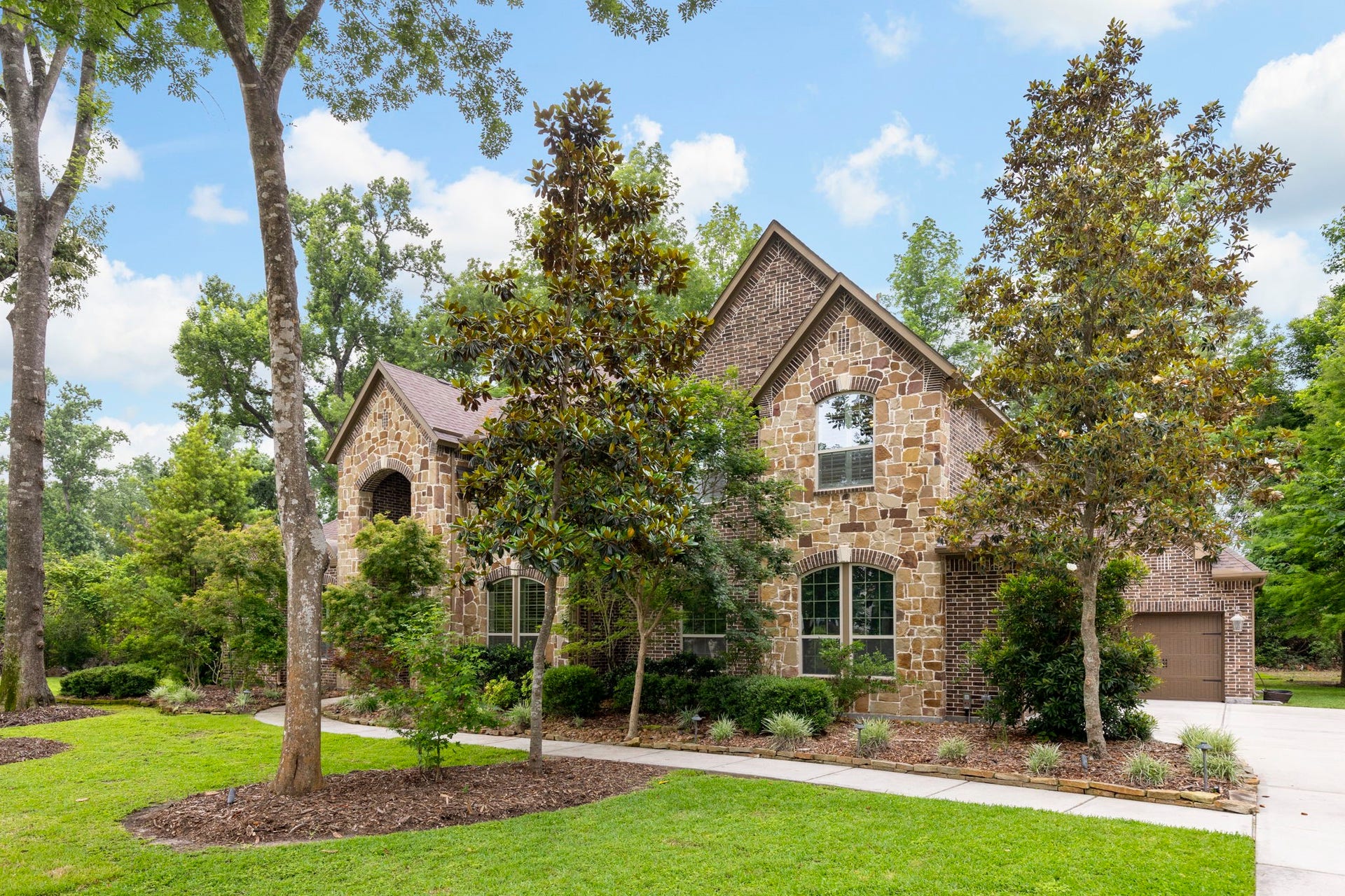 27015 Hidden Grove Landing Drive, Spring, TX 77386 Timeless brick and stone architecture surrounded by mature trees and exceptional privacy.