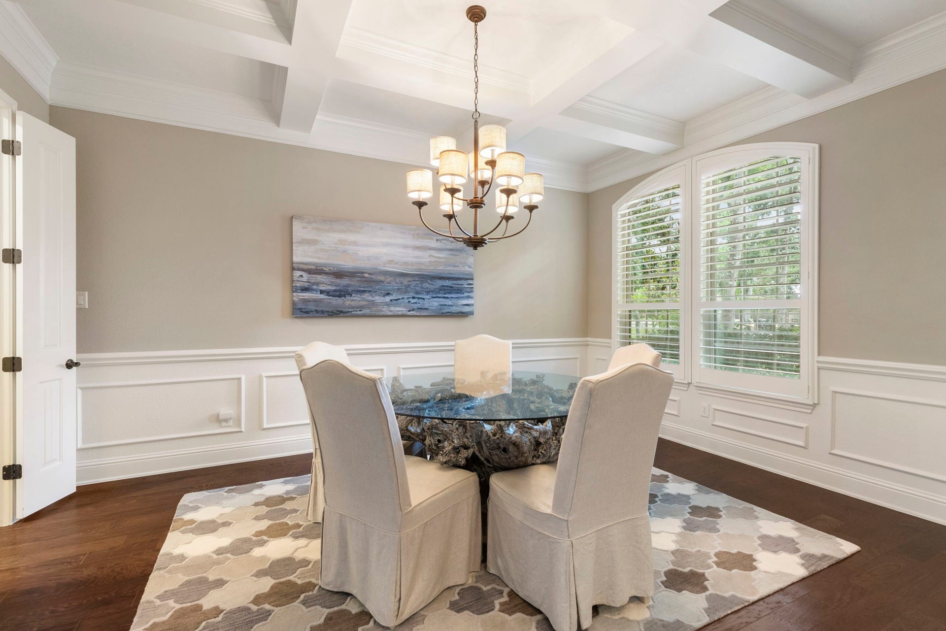 27015 Hidden Grove Landing Drive, Spring, TX 77386 Formal Dining Room with coffered ceiling, decorative chandelier, wood flooring, custom wall paneling, and convenient pass-through access to the Kitchen.