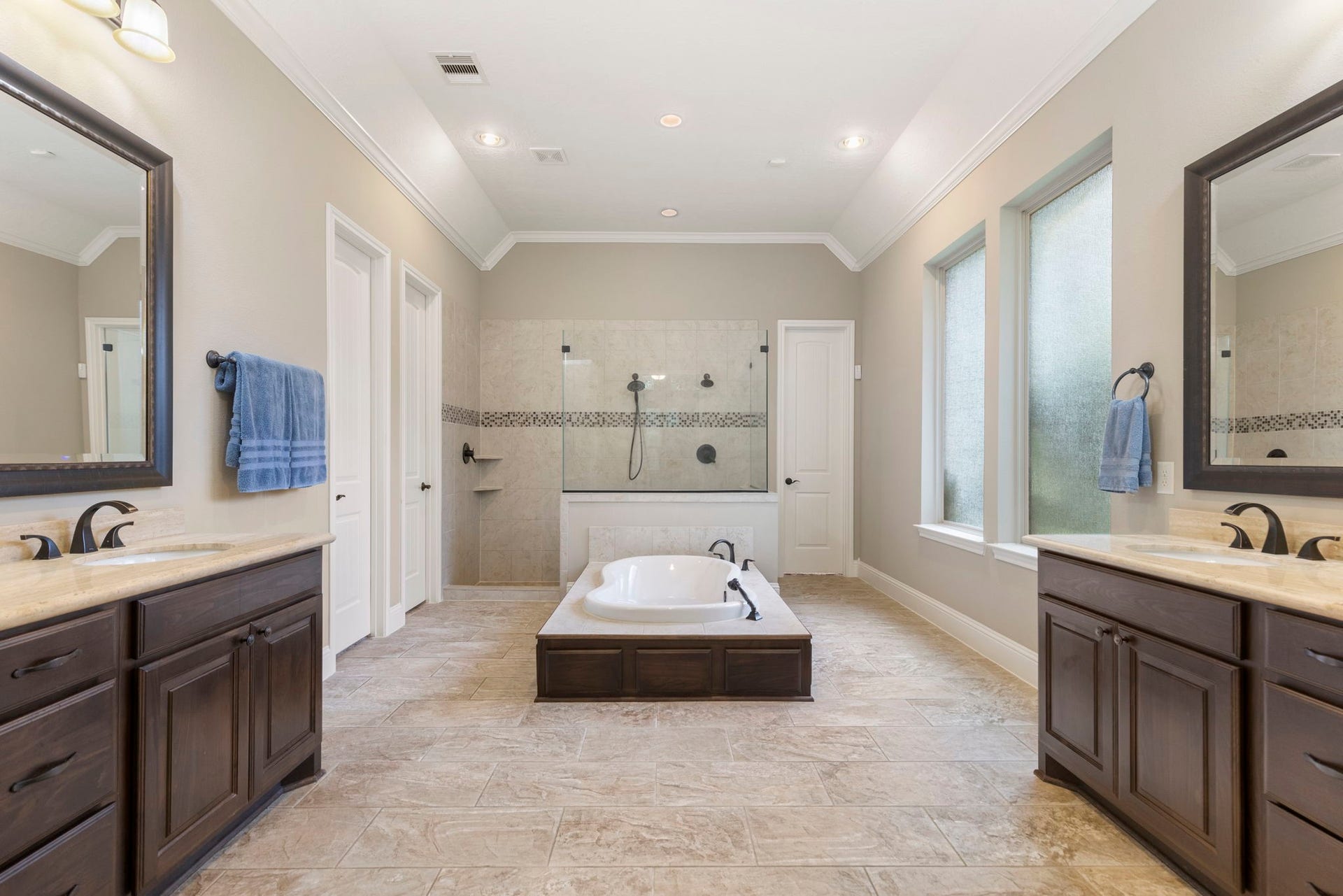27015 Hidden Grove Landing Drive, Spring, TX 77386 Luxurious Primary Bath with dual vanities, seated vanity area, drop-in jetted tub, walk-in shower with dual shower heads, and granite countertops.