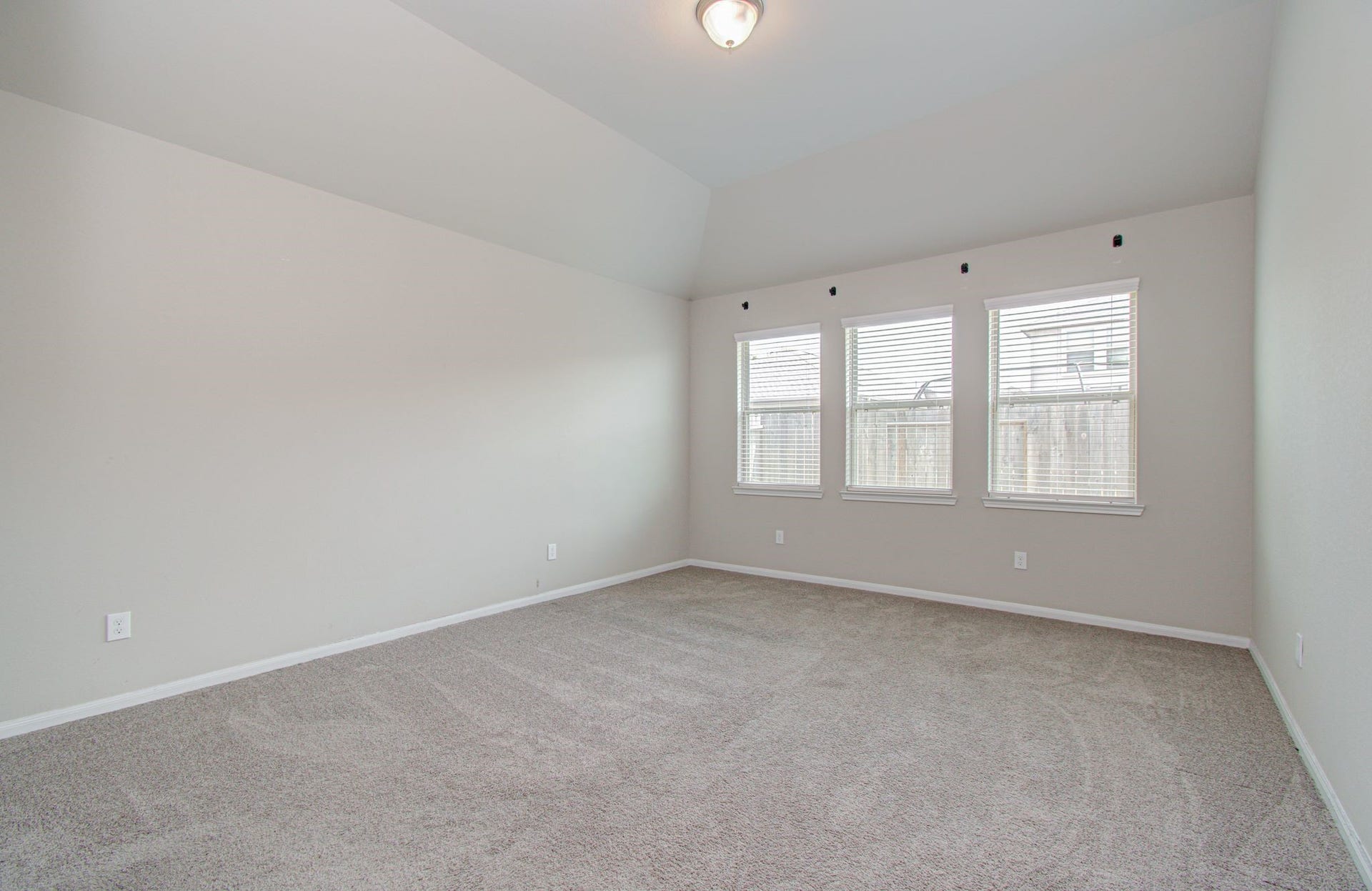 Spacious primary bedroom with upgraded triple-windows with upgraded faux wood blinds, all very nice.