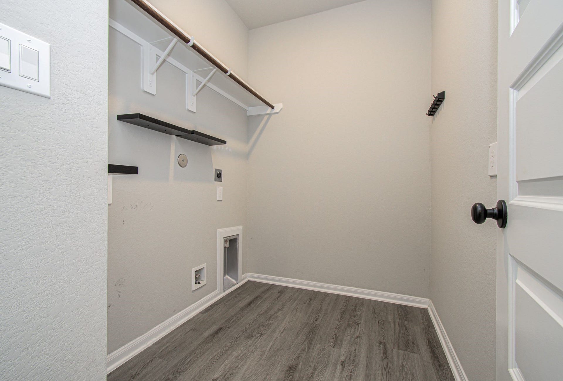 In home laundry / utility room with shelving and clothing rod