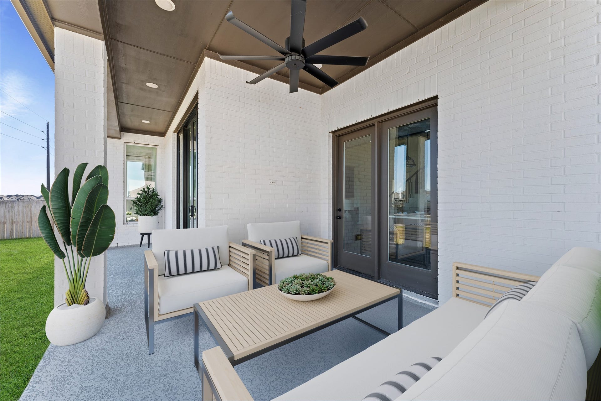 1934 Pleasant Grove Drive, Missouri City, TX 77459 Step outside to your expansive covered patio, a perfect sanctuary for year-round outdoor lounging and entertaining! This stylish space features a sleek, oversized ceiling fan to keep you cool, modern recessed lighting, and a beautiful view of your lush green backyard.