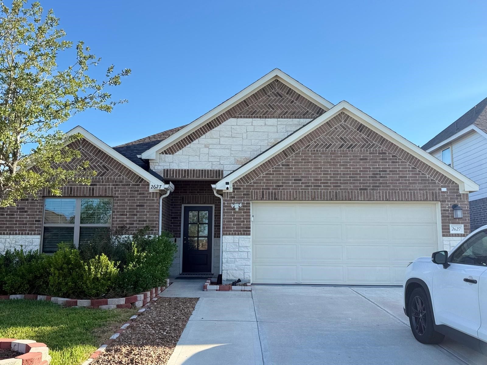 2627 Westward Hill Dr, Fresno, TX 77545 Charming brick home with a welcoming entrance, lush landscaping, and a spacious two-car garage.