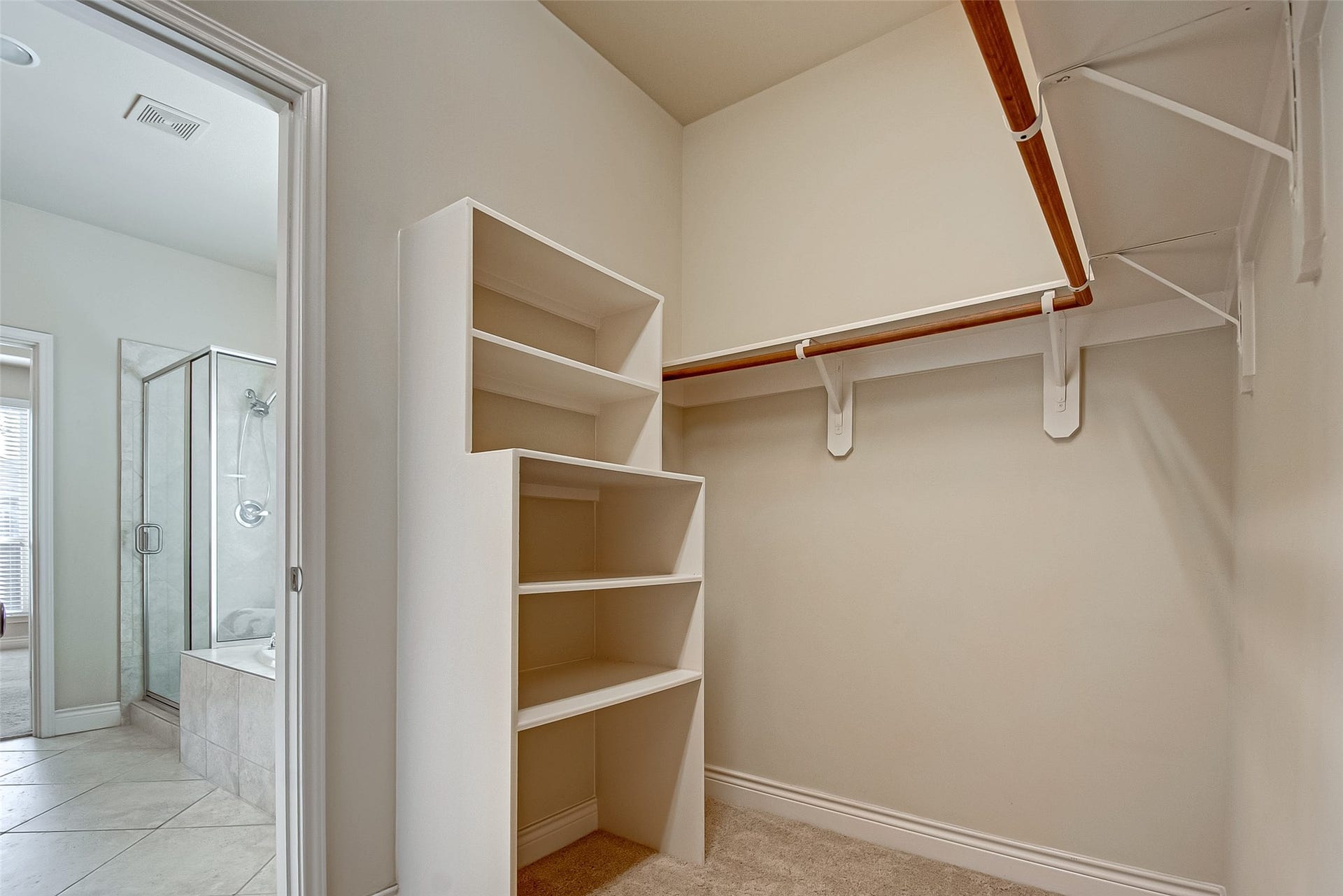 This spacious walk-in closet features built-in storage shelves.