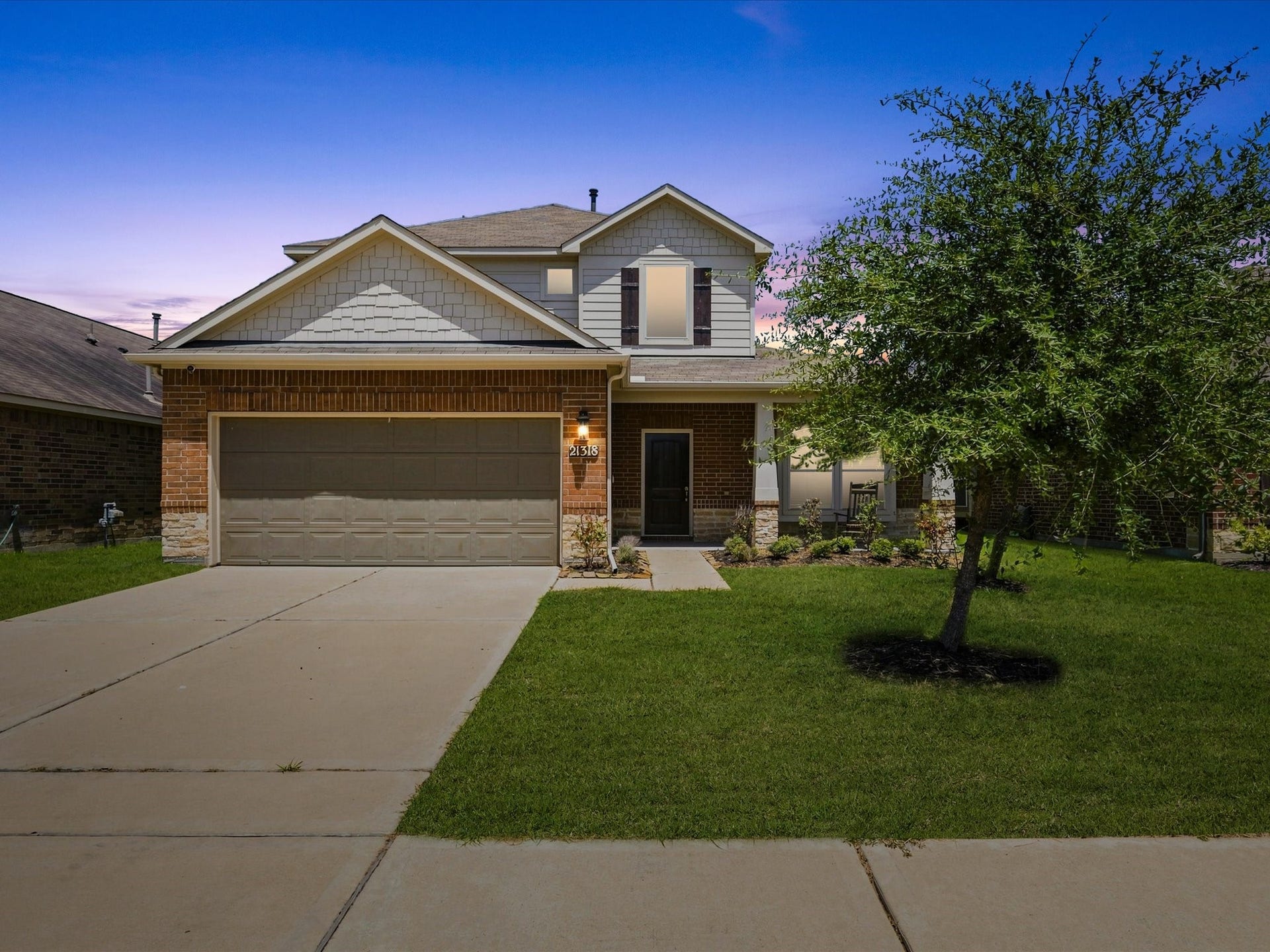 21318 Cypress White Oak Drive, Cypress, TX 77433 A welcoming first impression begins with the home's beautiful brick and stone exterior, inviting front entry, and lush green lawn (lawn color digitally enhanced).