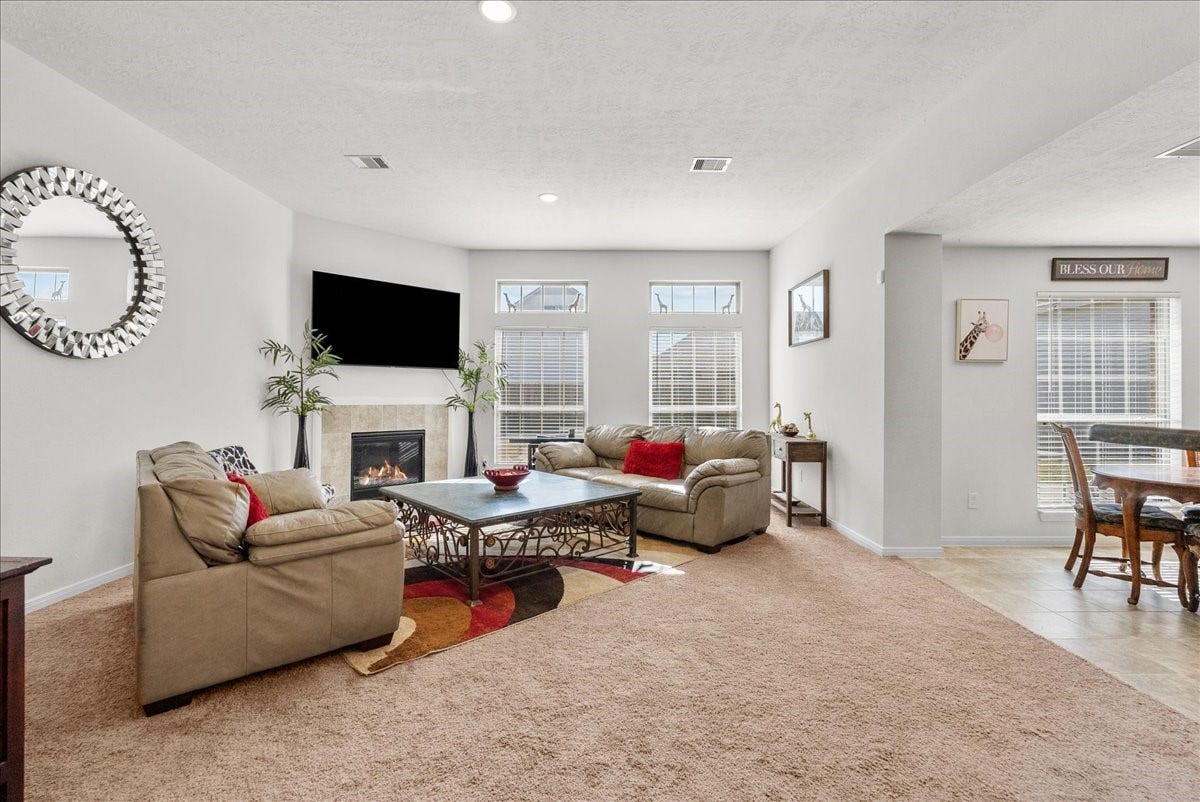 2111 Gilbert Road, Dickinson, TX 77539 The living room features a cozy fireplace and is bathed in natural morning light through an abundance of windows