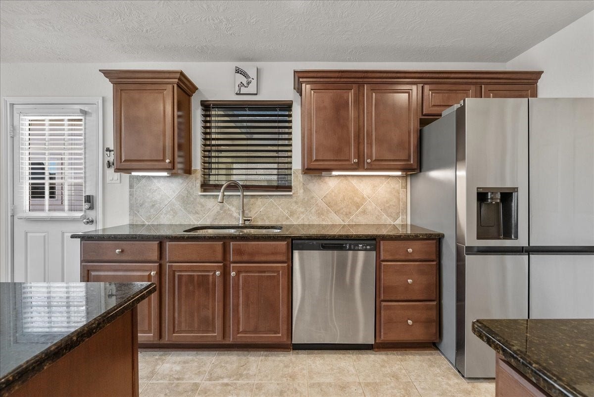 2111 Gilbert Road, Dickinson, TX 77539 Chef's eat-in island kitchen features 42" cabinets with crown molding, granite countertops, stainless steel appliances and a breakfast bar