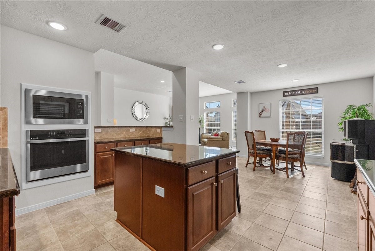 2111 Gilbert Road, Dickinson, TX 77539 Chef's eat-in island kitchen features 42" cabinets with crown molding, granite countertops, stainless steel appliances and a breakfast bar