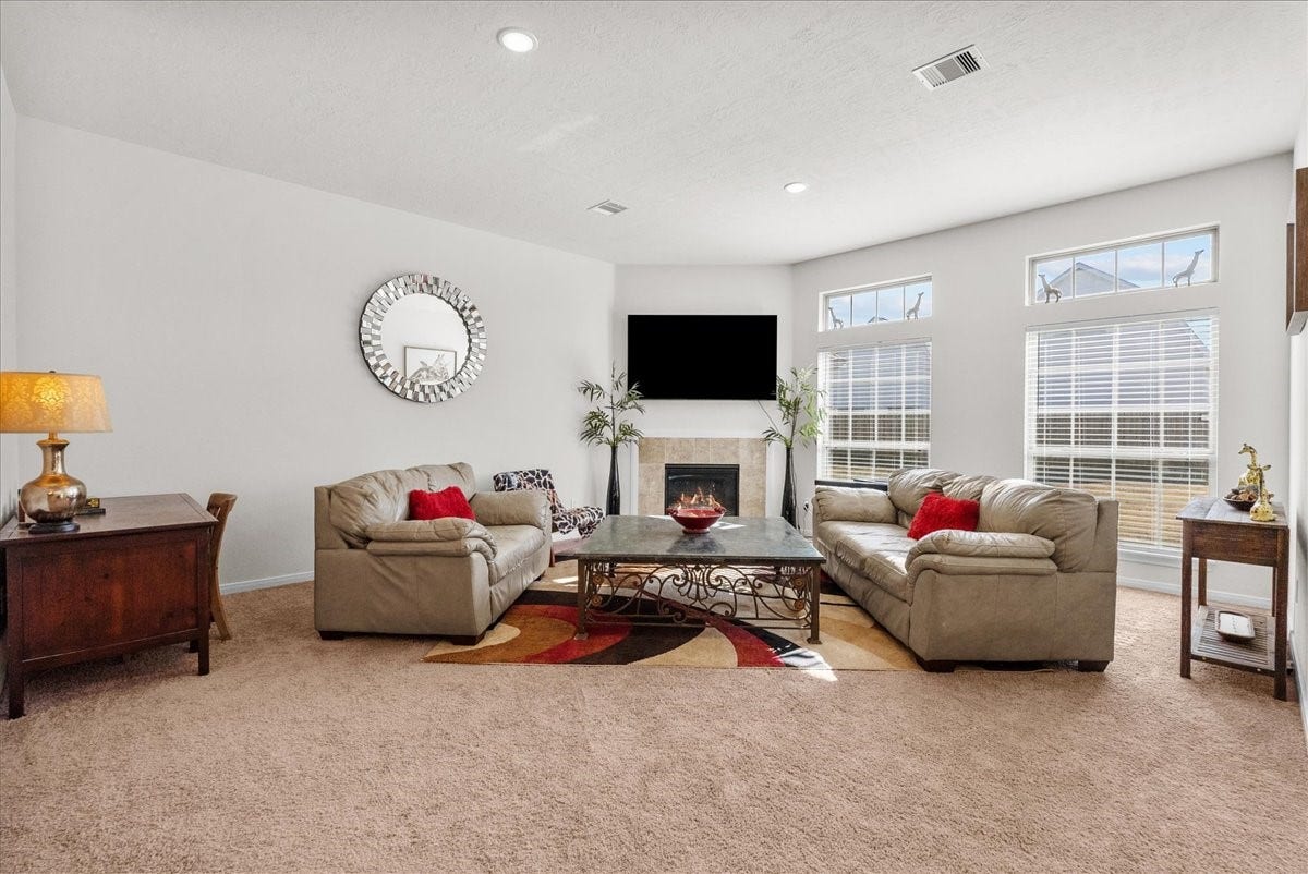 2111 Gilbert Road, Dickinson, TX 77539 The living room features a cozy fireplace and is bathed in natural morning light through an abundance of windows