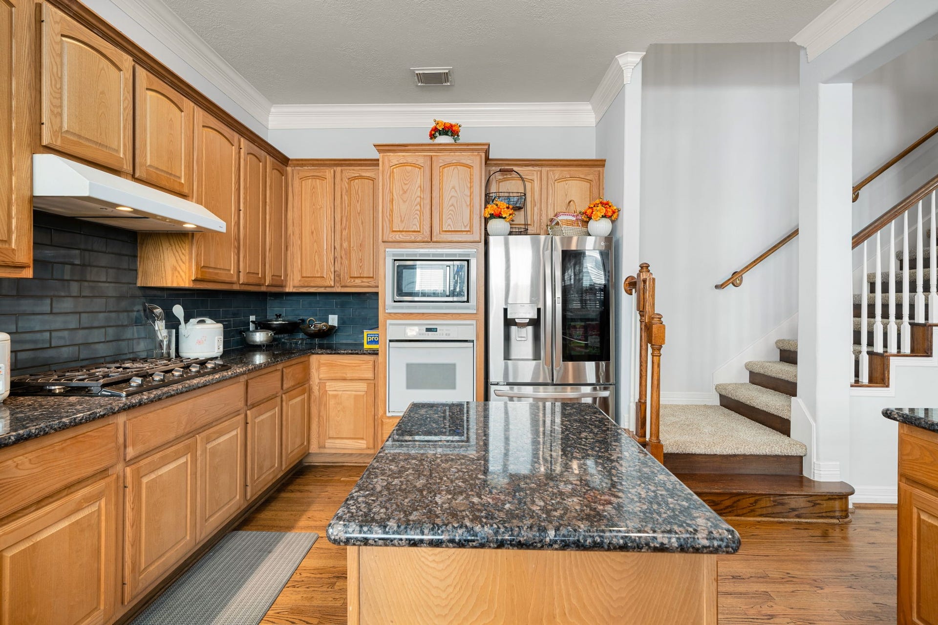 6309 Mapleridge Street, Houston, TX 77081 Bright kitchen featuring granite countertops, gas cooktop, center island, and ample cabinet storage.