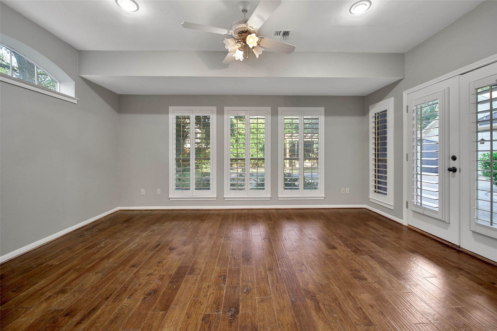 5814 Woodland Creek Drive, Kingwood, TX 77345 Flex room off the primary has lots of windows and french door access to the patio. Plantation shutters on the windows make this room elegant and also private.