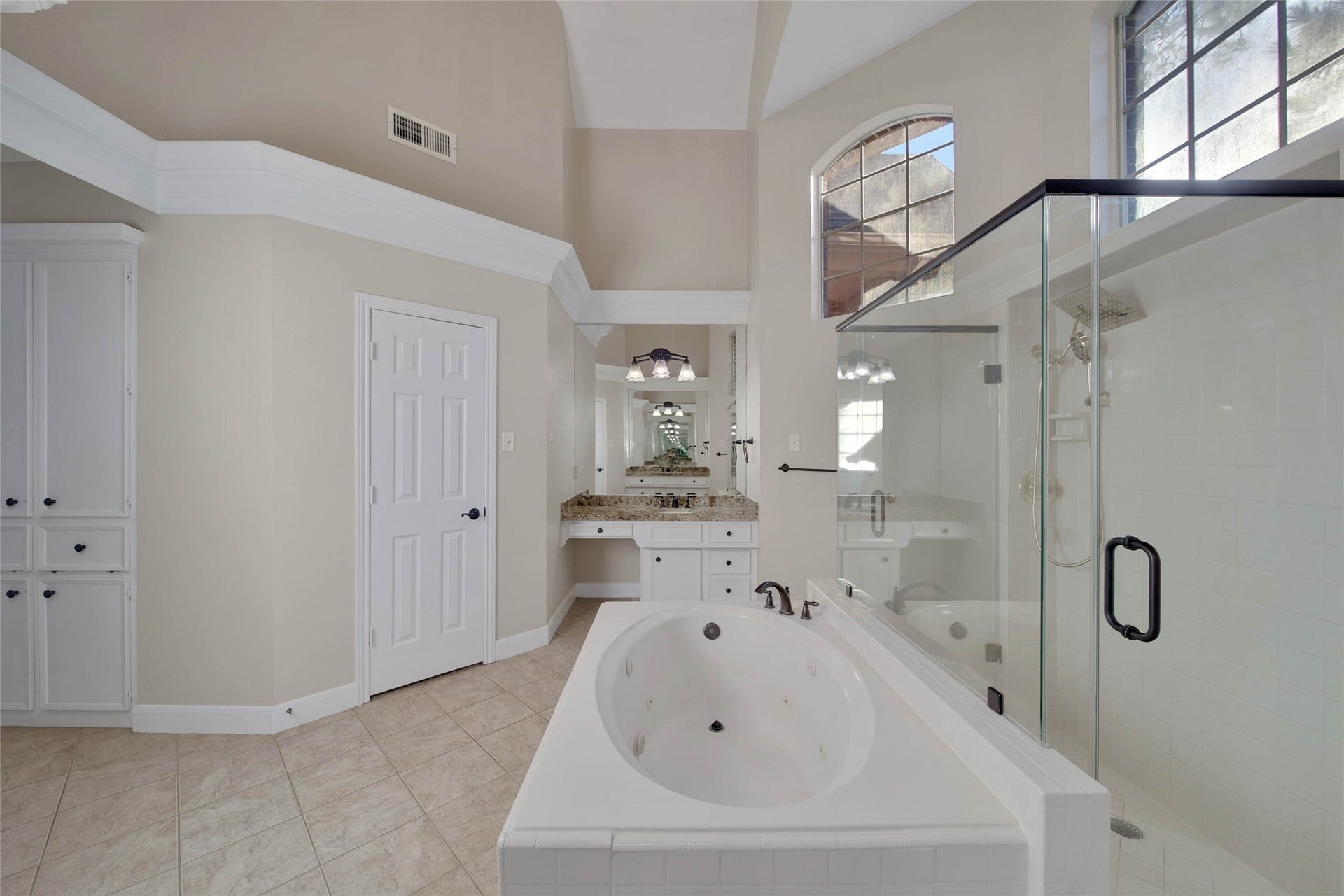 5814 Woodland Creek Drive, Kingwood, TX 77345 Separate whirlpool tub huge oversize shower with two doors, high ceilings and bright windows up high, separate vanities and lots of storage make this a fabulous bathroom.