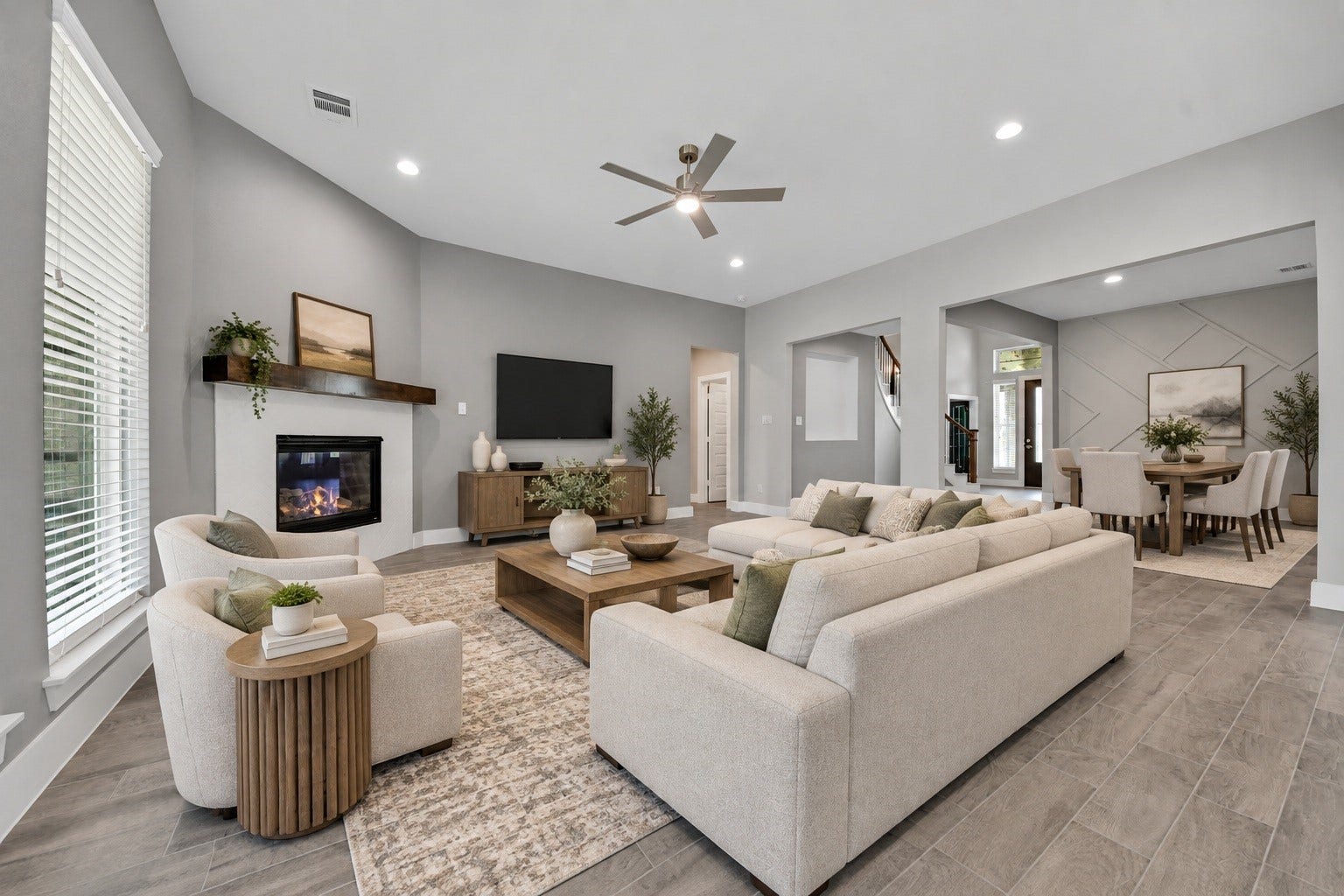 23619 Iris Field Court, Katy, TX 77493 Virtually Staged. Spacious open-concept living area featuring a modern fireplace, soaring ceiling, abundant natural light, and seamless flow into the dining and entry spaces.