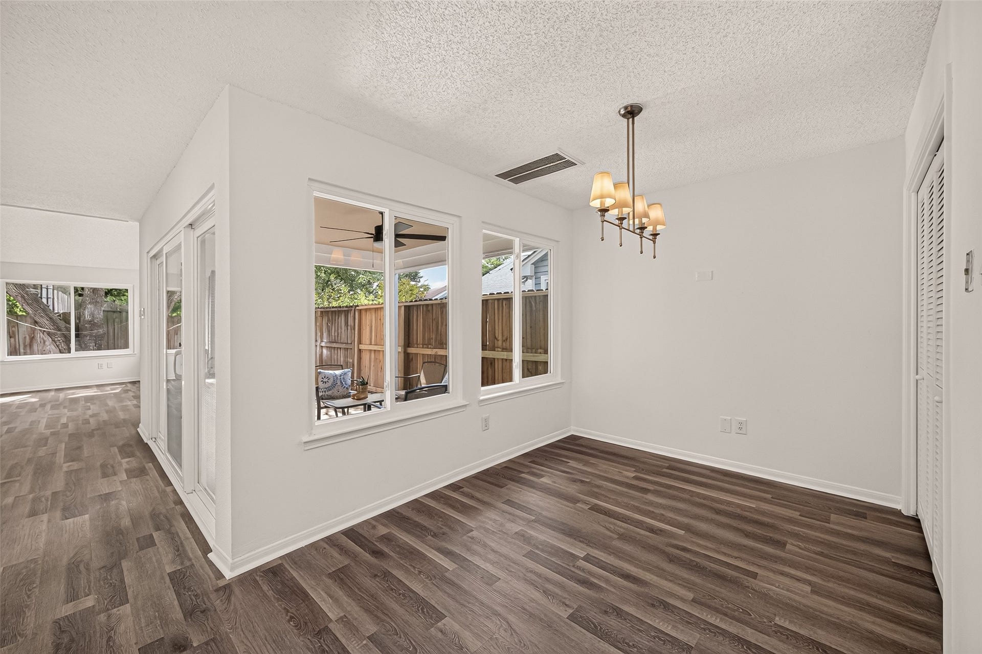 12747 Ashford Knoll Drive, Houston, TX 77082 Bright breakfast area with modern chandelier and large windows offering a view of the cover patio.