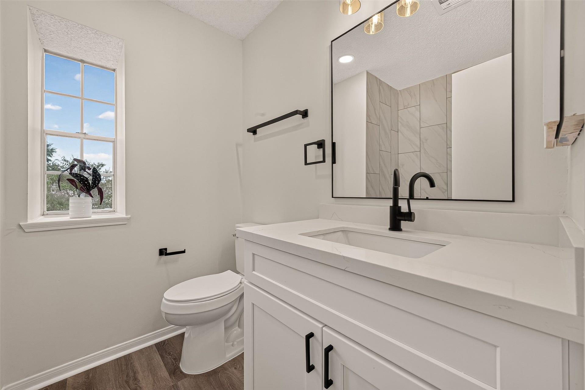 12747 Ashford Knoll Drive, Houston, TX 77082 Bright and modern secondary bathroom upstairs featuring sleek fixtures, a large mirror, and a window offering natural light.