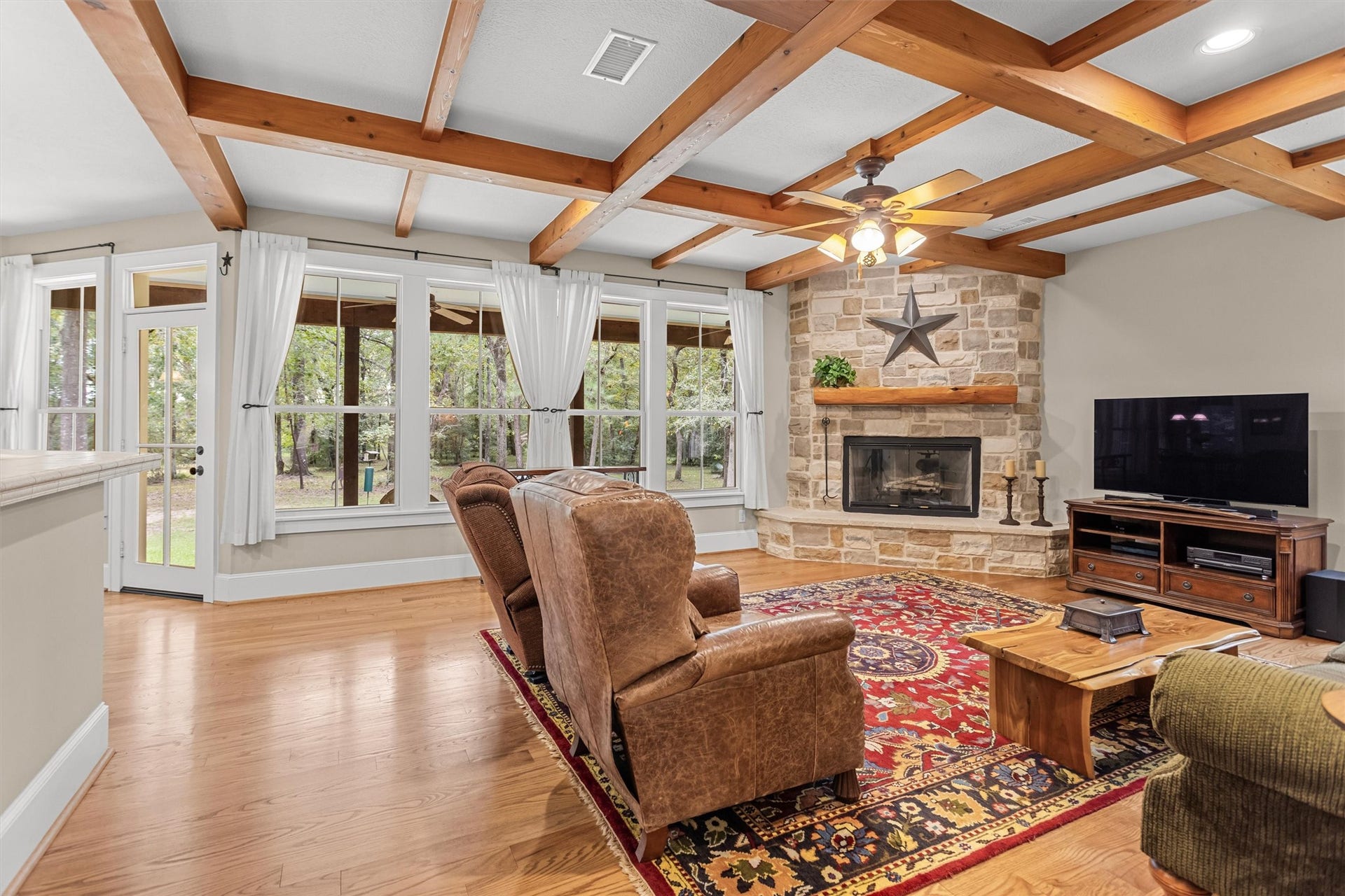 18181 Rabon Chapel Road, Montgomery, TX 77316 Beamed ceilings and a stone fireplace anchor the living room