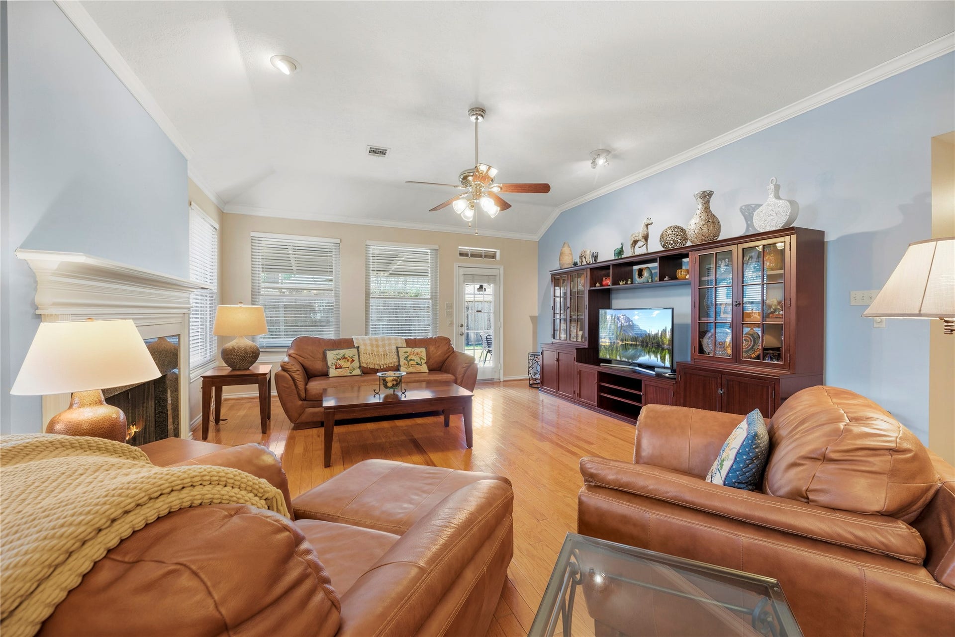 Spacious living room with elegant hardwood floors, abundant natural light, and a cozy fireplace, perfect for relaxation and entertainment.
