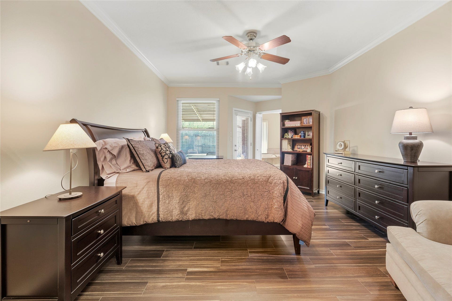 Spacious primary bedroom with elegant flooring.